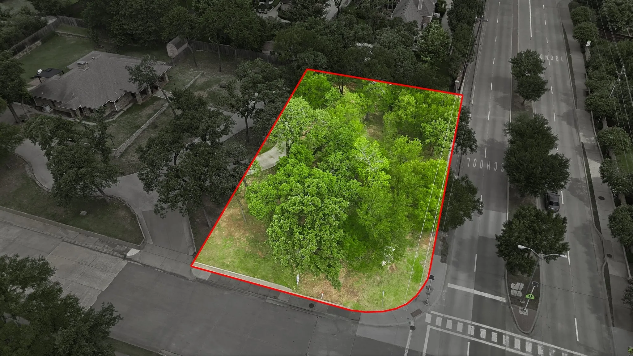 Expansive corner lot featuring mature trees and a manicured lawn