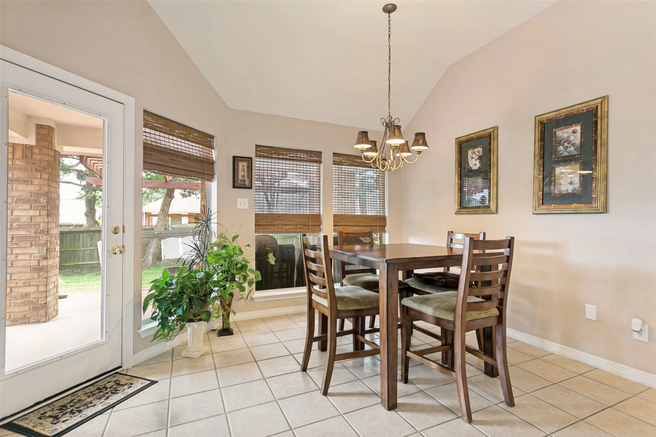 Dining area featuring vaulted ceilings, tile flooring, and a chandelier