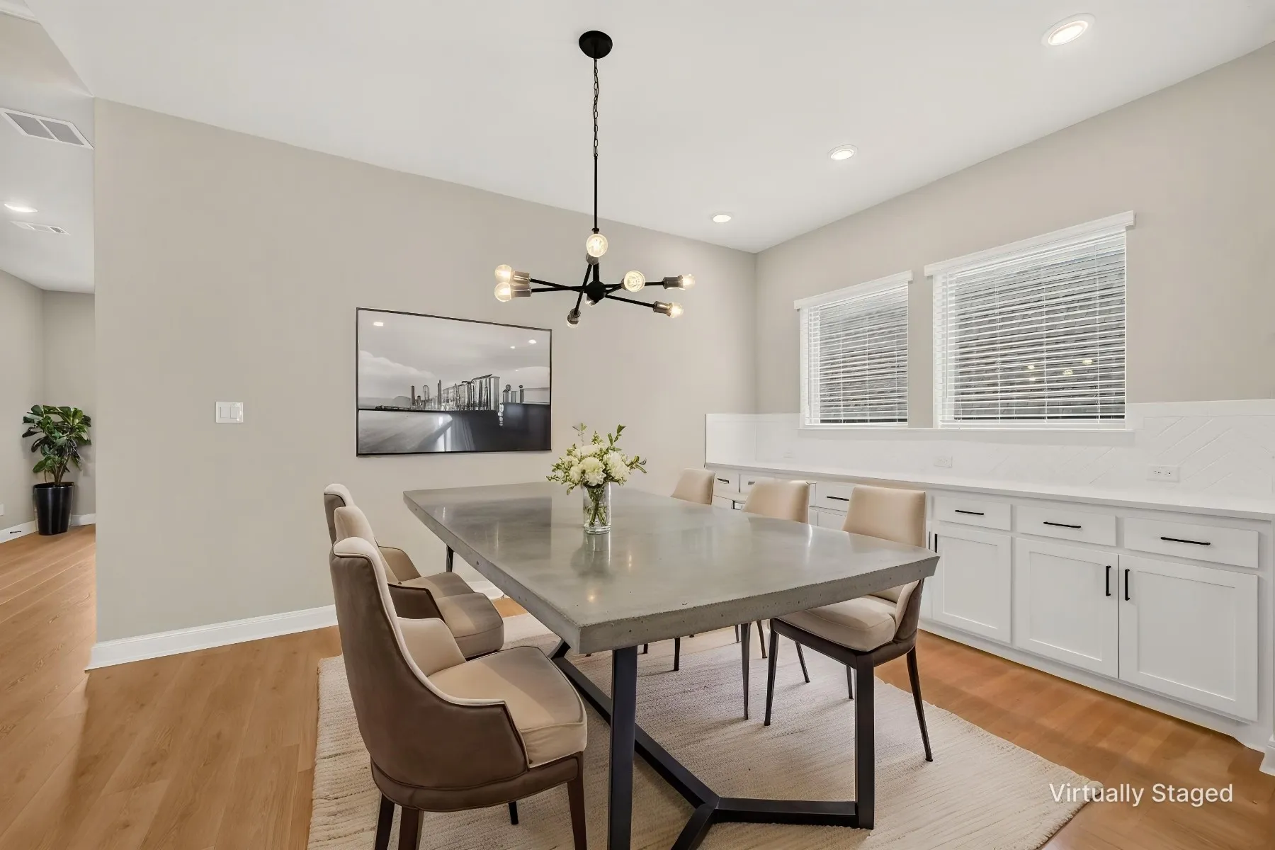 Dining area featuring wood-finish flooring, a contemporary chandelier, recessed lighting, and a built-in buffet with white cabinetry and a patterned backsplash