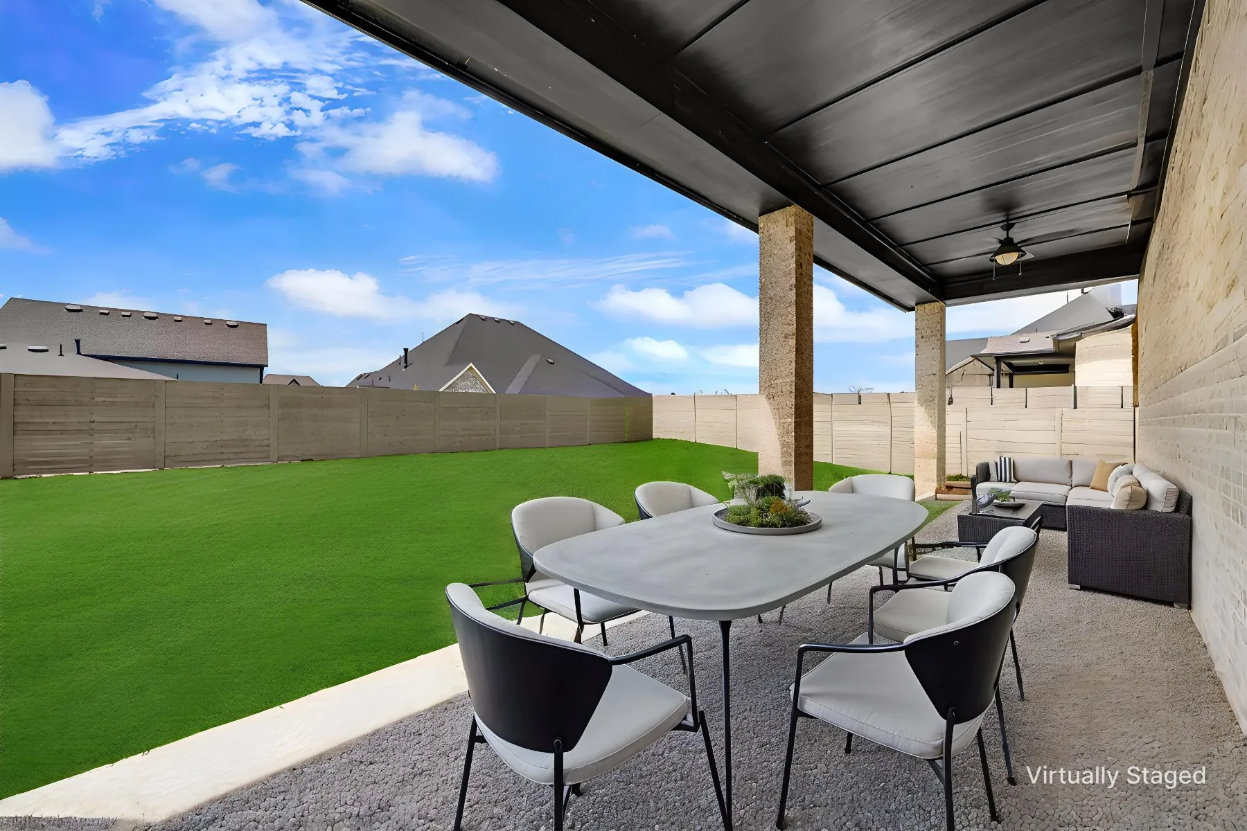 Covered patio featuring a ceiling fan and recessed lighting, complemented by a brick exterior wall