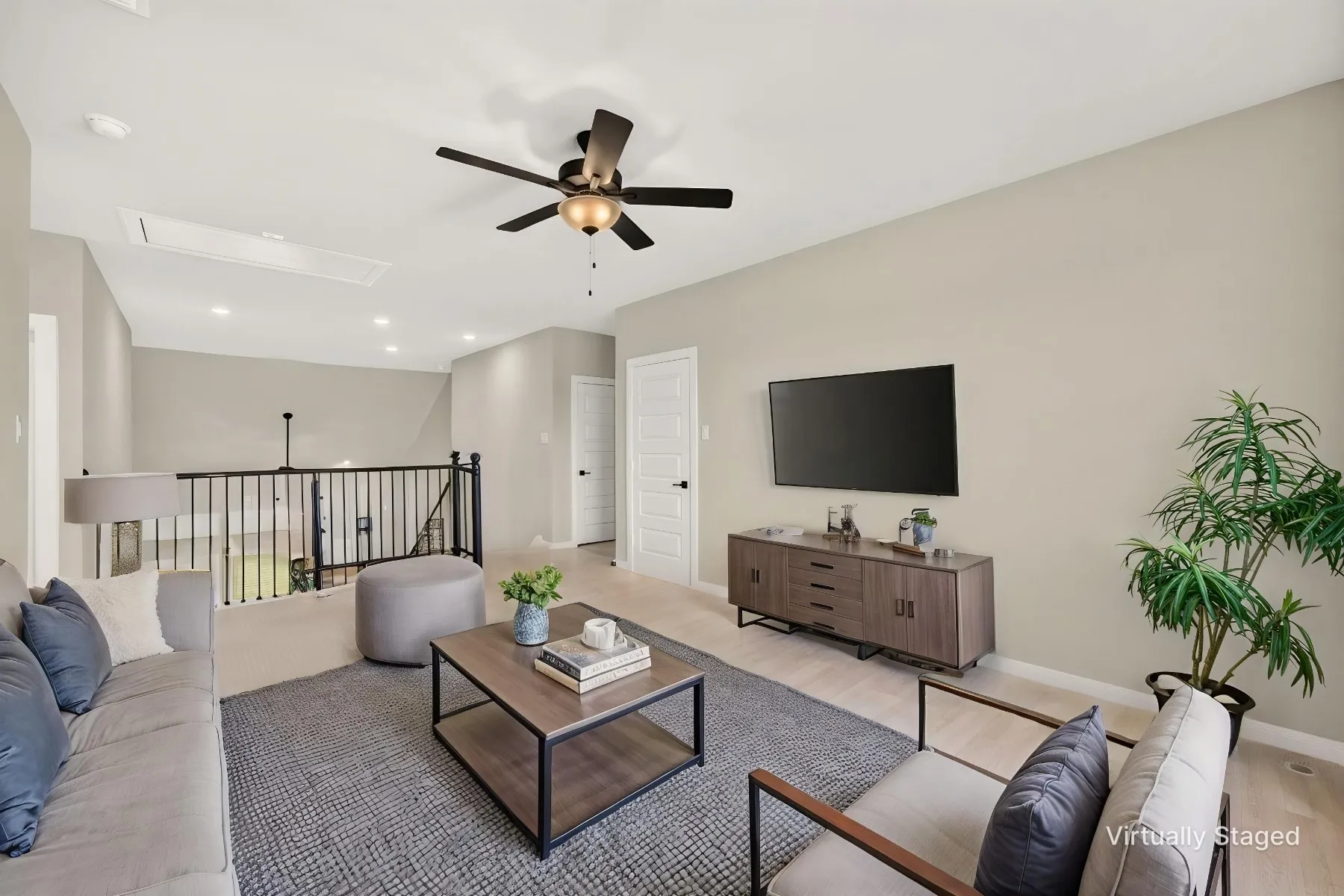 Open concept living area featuring light-toned walls and wood-finish flooring
