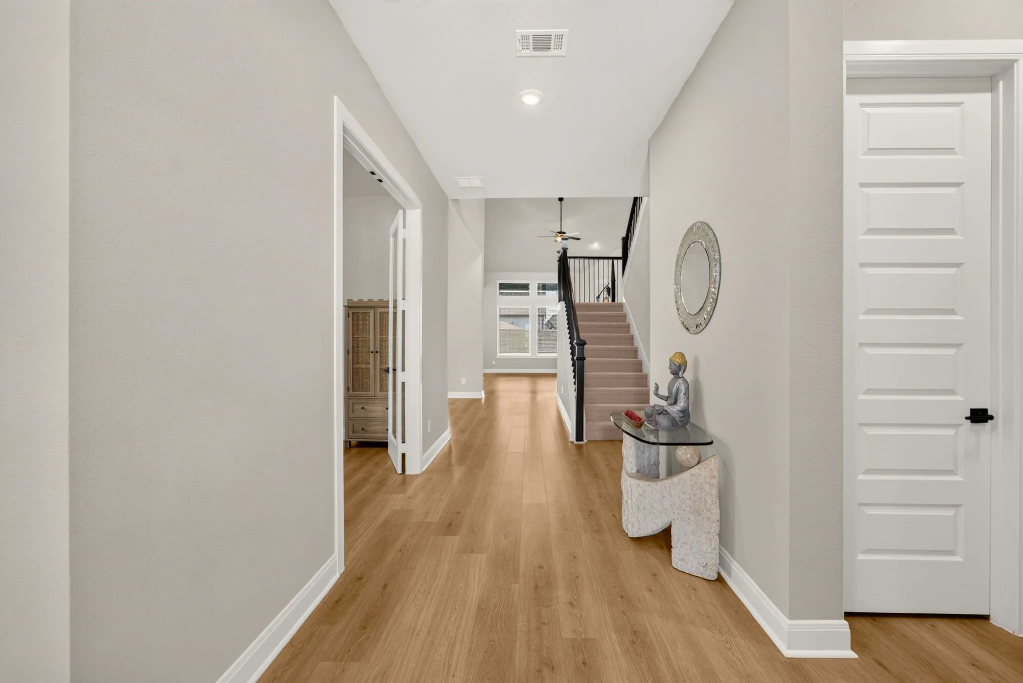Light wood-finish flooring extending through a spacious hallway