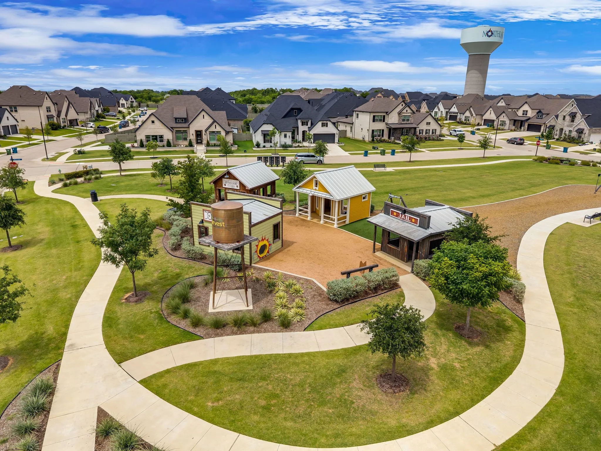 Community park featuring walking paths, mature landscaping, and shaded seating areas