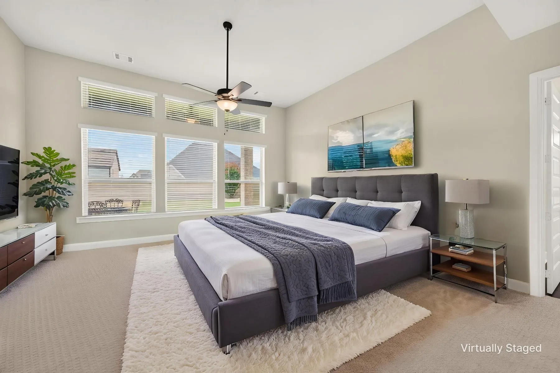 Spacious room featuring multiple windows with blinds, a vaulted ceiling, and a ceiling fan with integrated lighting