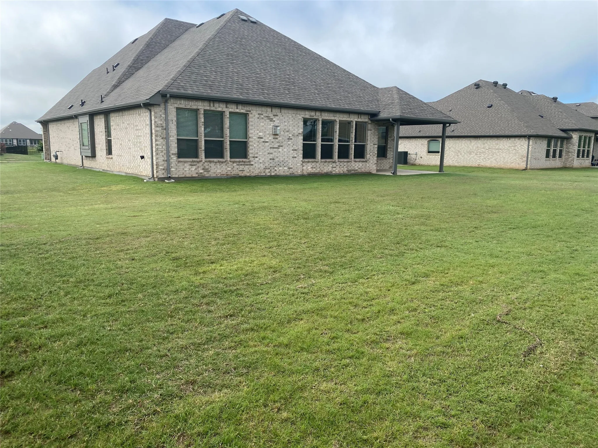 View of side of property with a patio and a yard