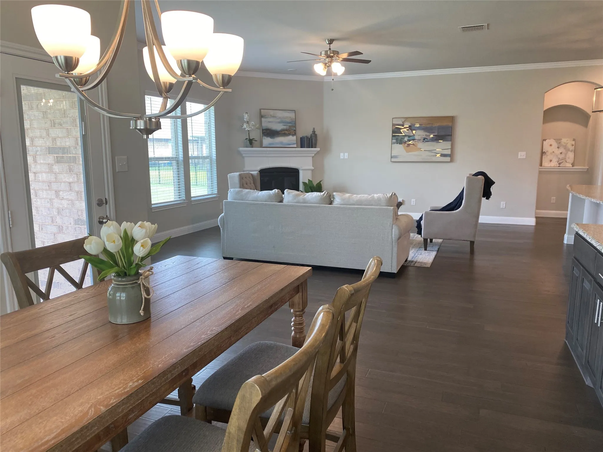 Dining room with dark hardwood / wood-style flooring, crown molding, and a chandelier