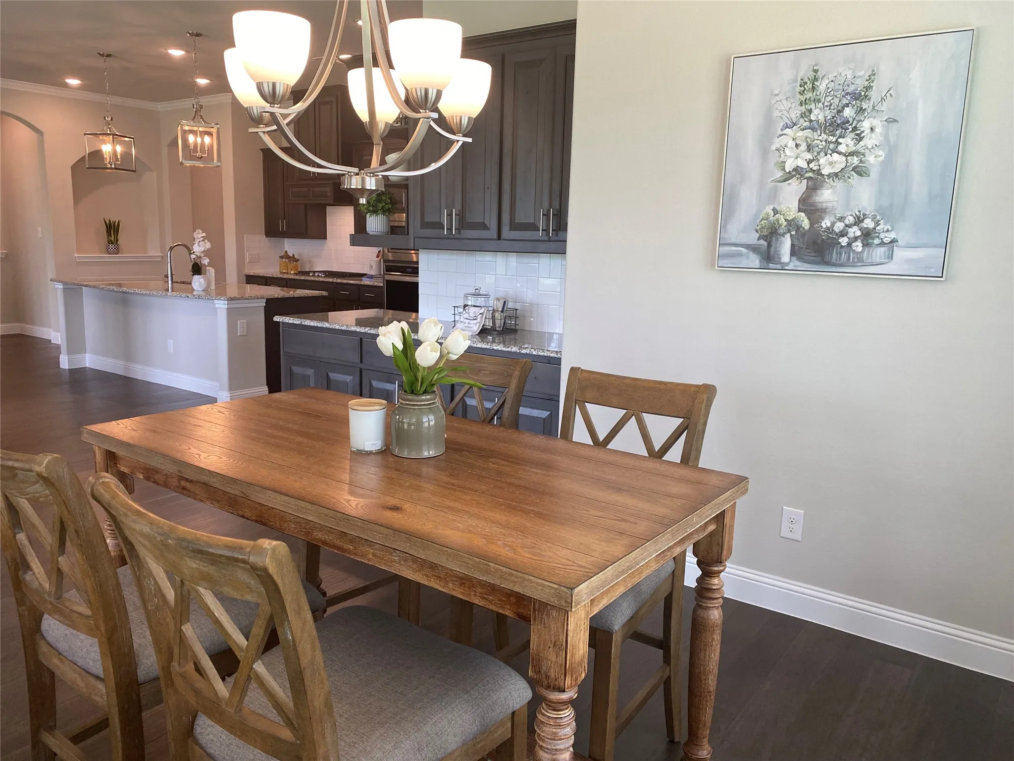 Dining room with an inviting chandelier, sink, crown molding, and dark hardwood / wood-style floors