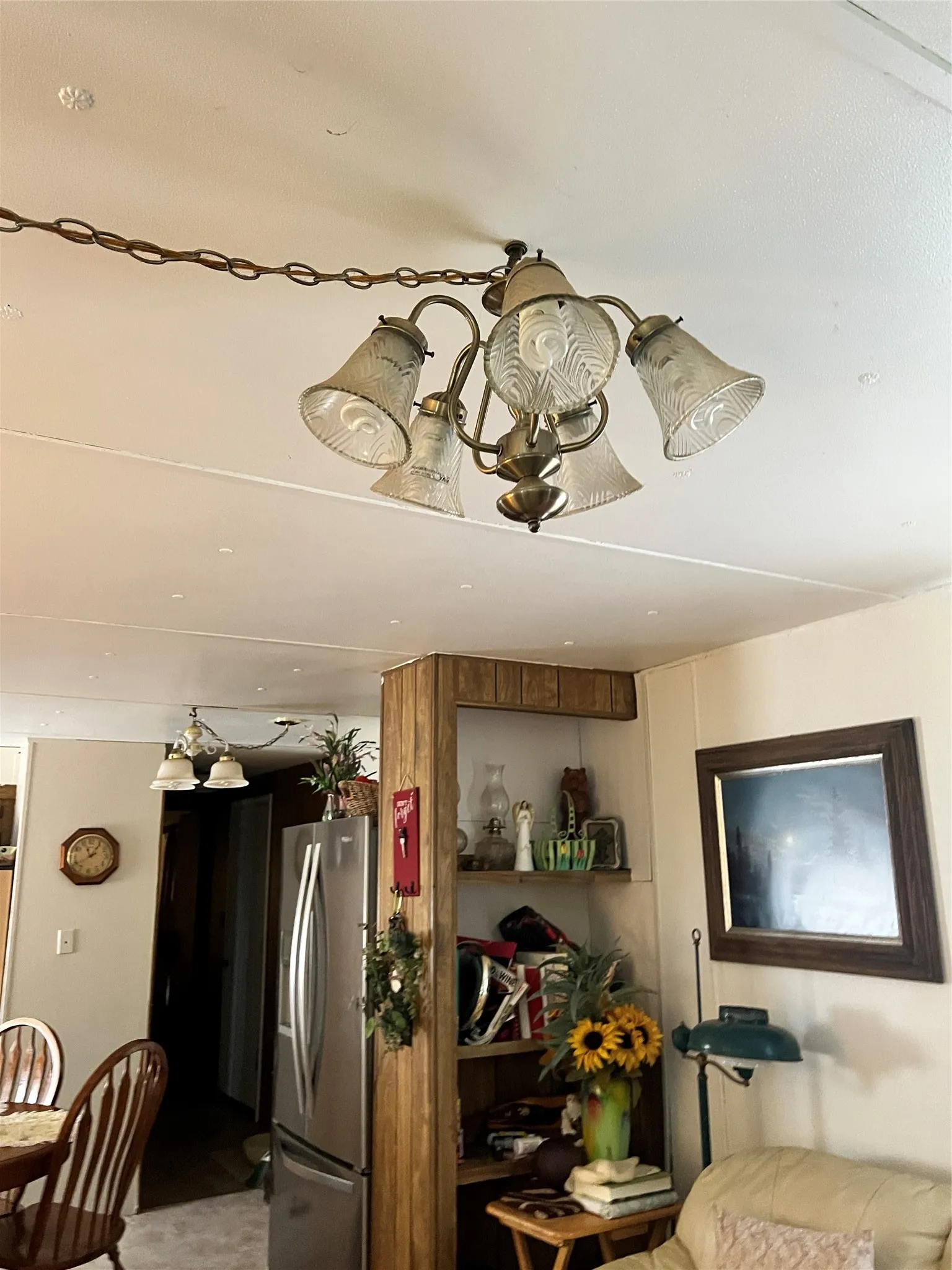 Kitchen with freestanding refrigerator, a chandelier, and light flooring