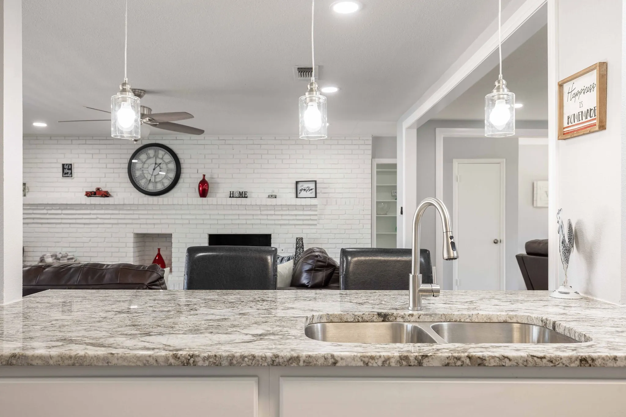 Kitchen with a sink, a ceiling fan, light stone countertops, hanging light fixtures, and recessed lighting