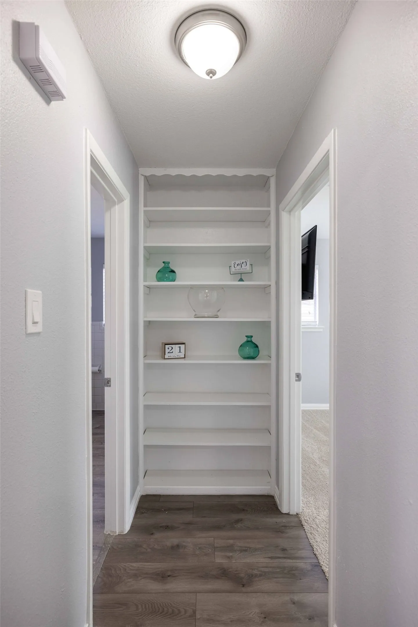 Corridor with dark wood-style floors and a textured ceiling