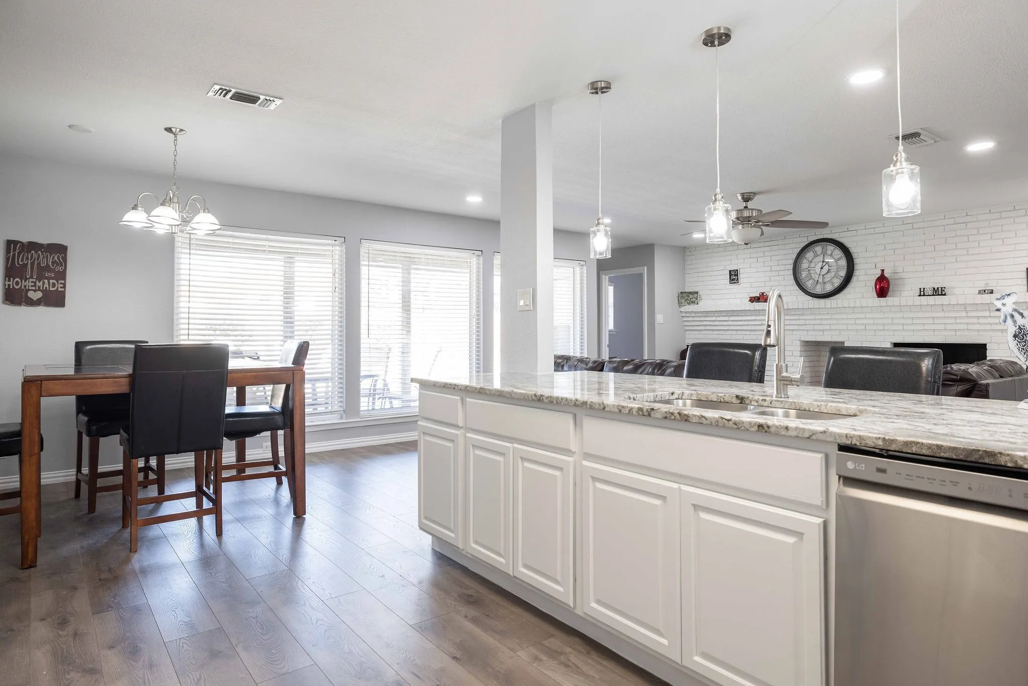 Kitchen with dishwasher, a fireplace, open floor plan, a sink, and ceiling fan