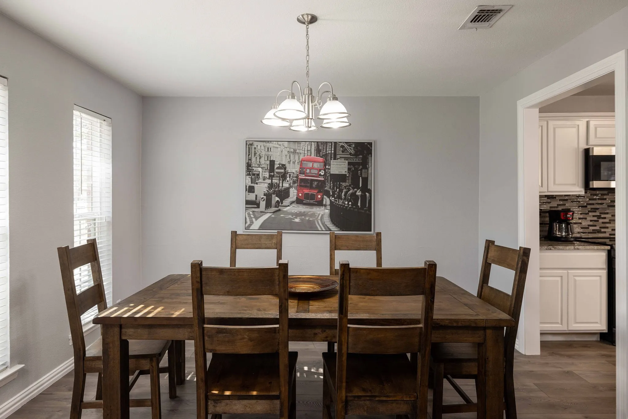 Dining area with a chandelier and dark wood-style flooring