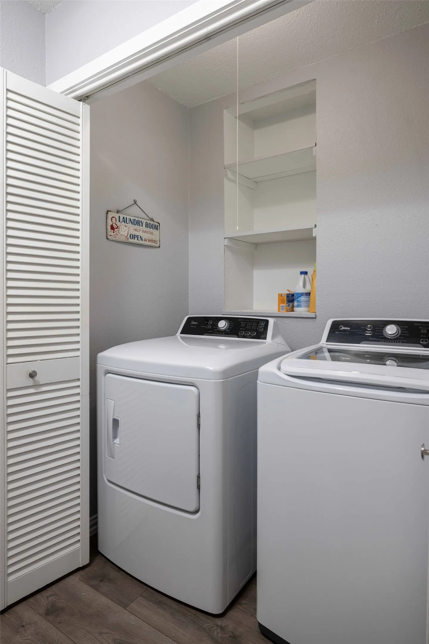 Washroom with washing machine and dryer and dark wood-style flooring