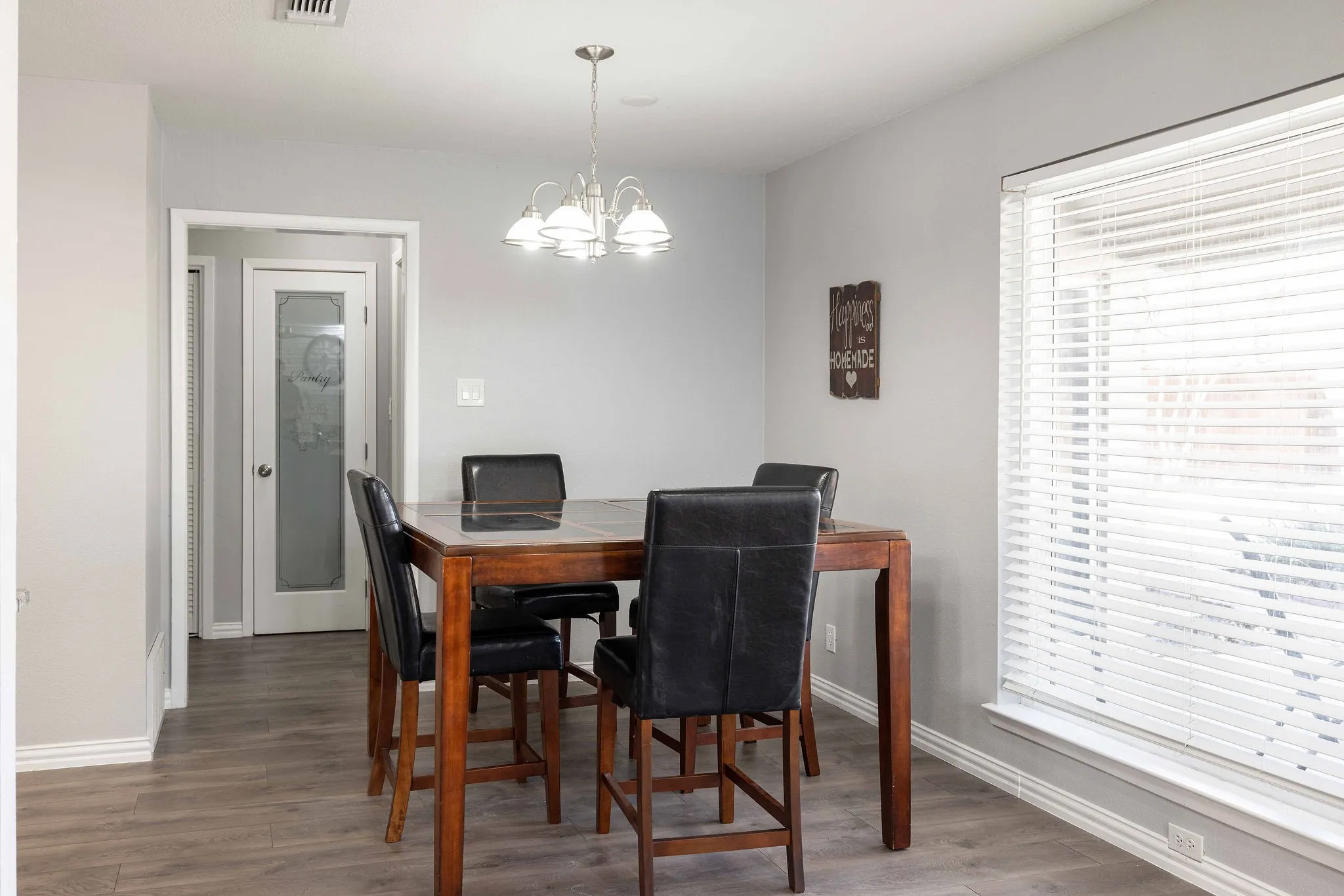 Dining room featuring baseboards, wood finished floors, and a chandelier