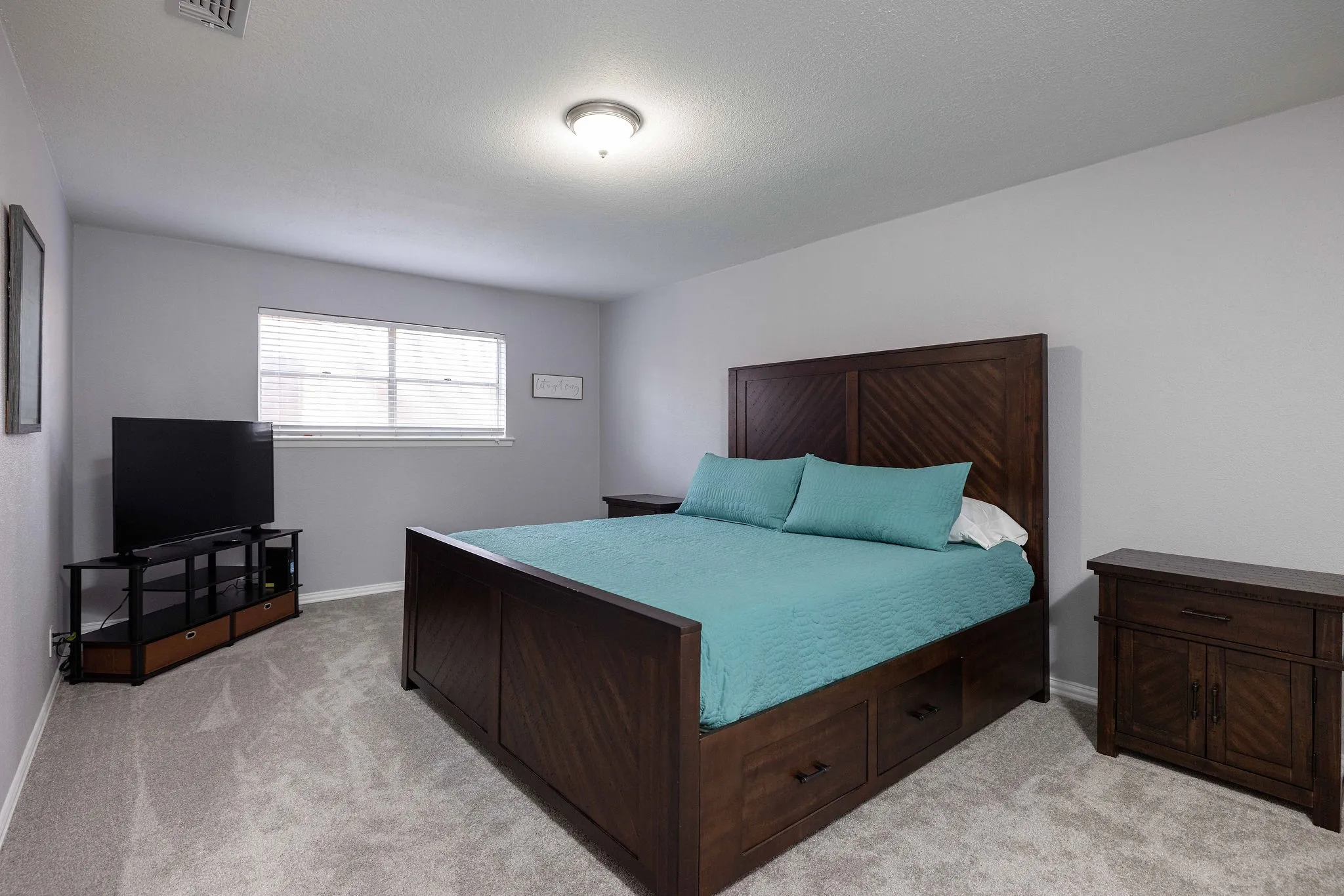 Bedroom with light colored carpet and baseboards