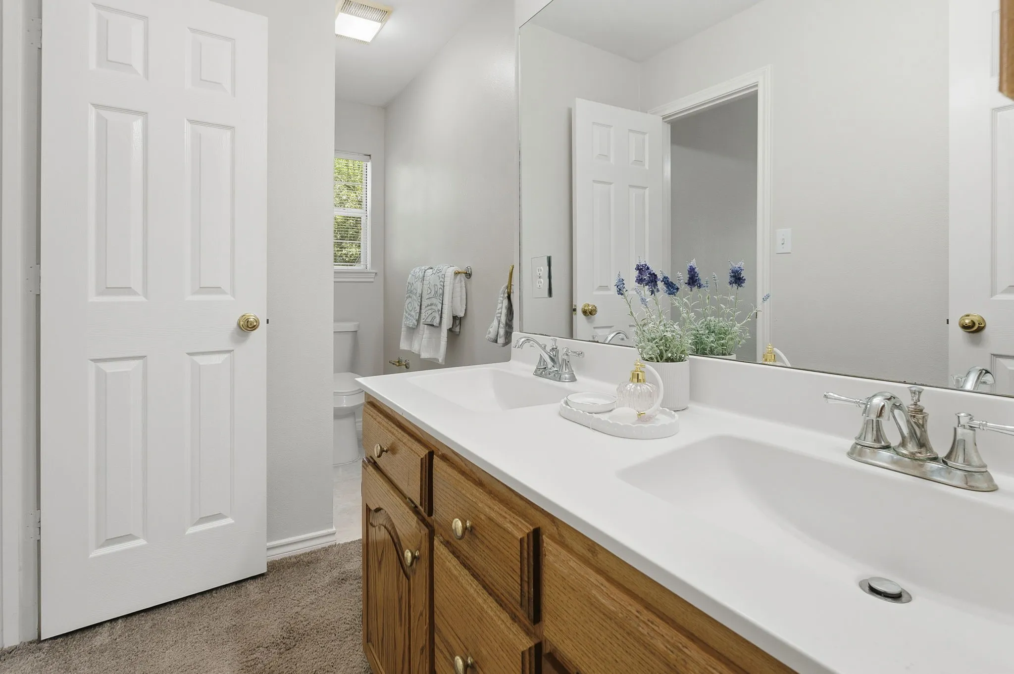 Secondary bathroom with dual sinks, extra storage and tub/shower combo.