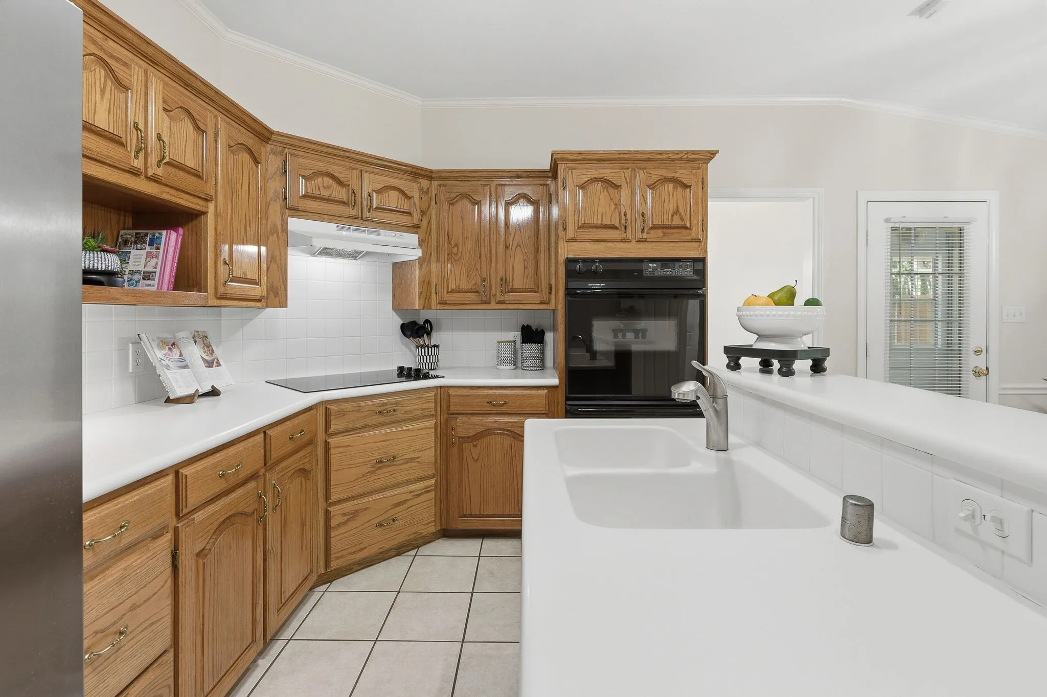 The kitchen offers custom wood cabinetry, electric appliances, double ovens, a serving bar, great cabinet space, and two pantries.