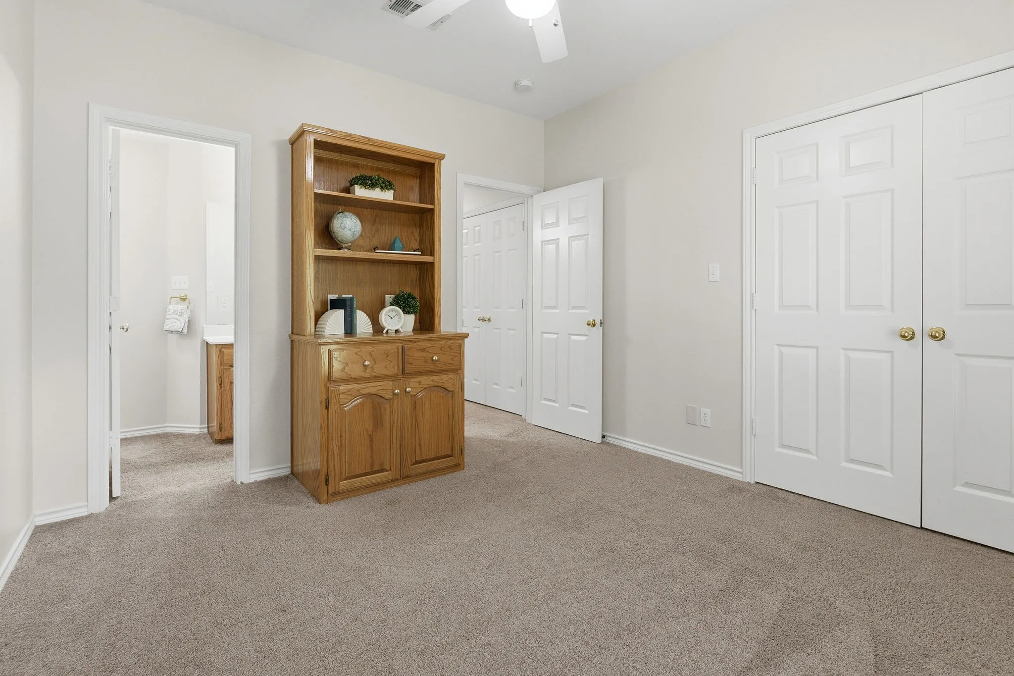 Secondary bedroom includes built-ins and a large closet with extra storage.