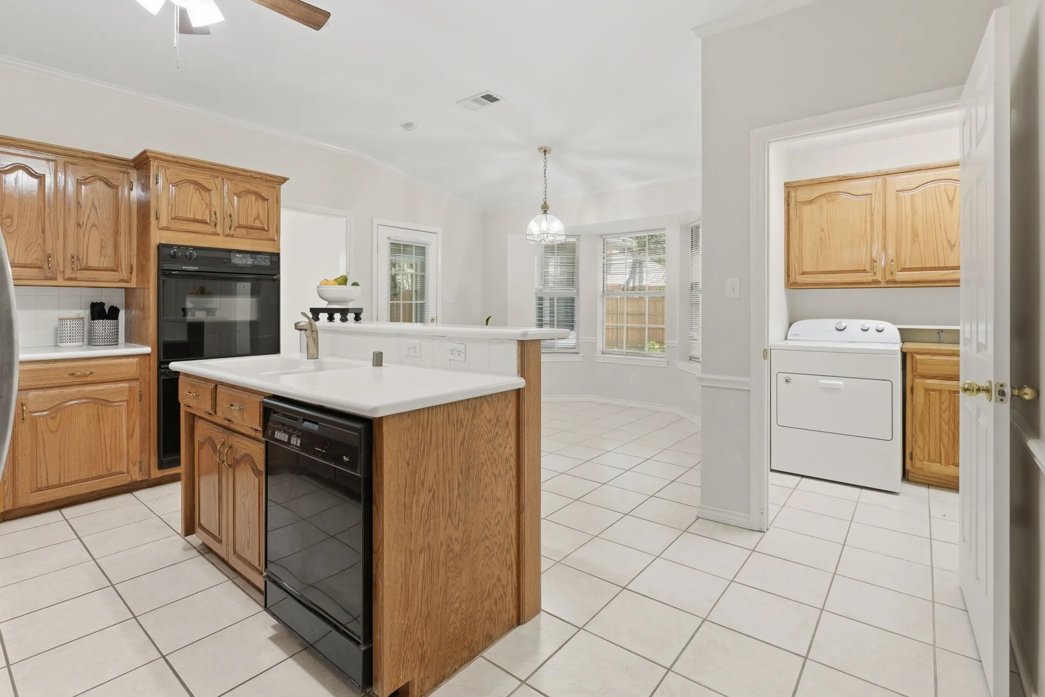 The kitchen offers custom wood cabinetry, electric appliances, double ovens, a serving bar, great cabinet space, and two pantries.