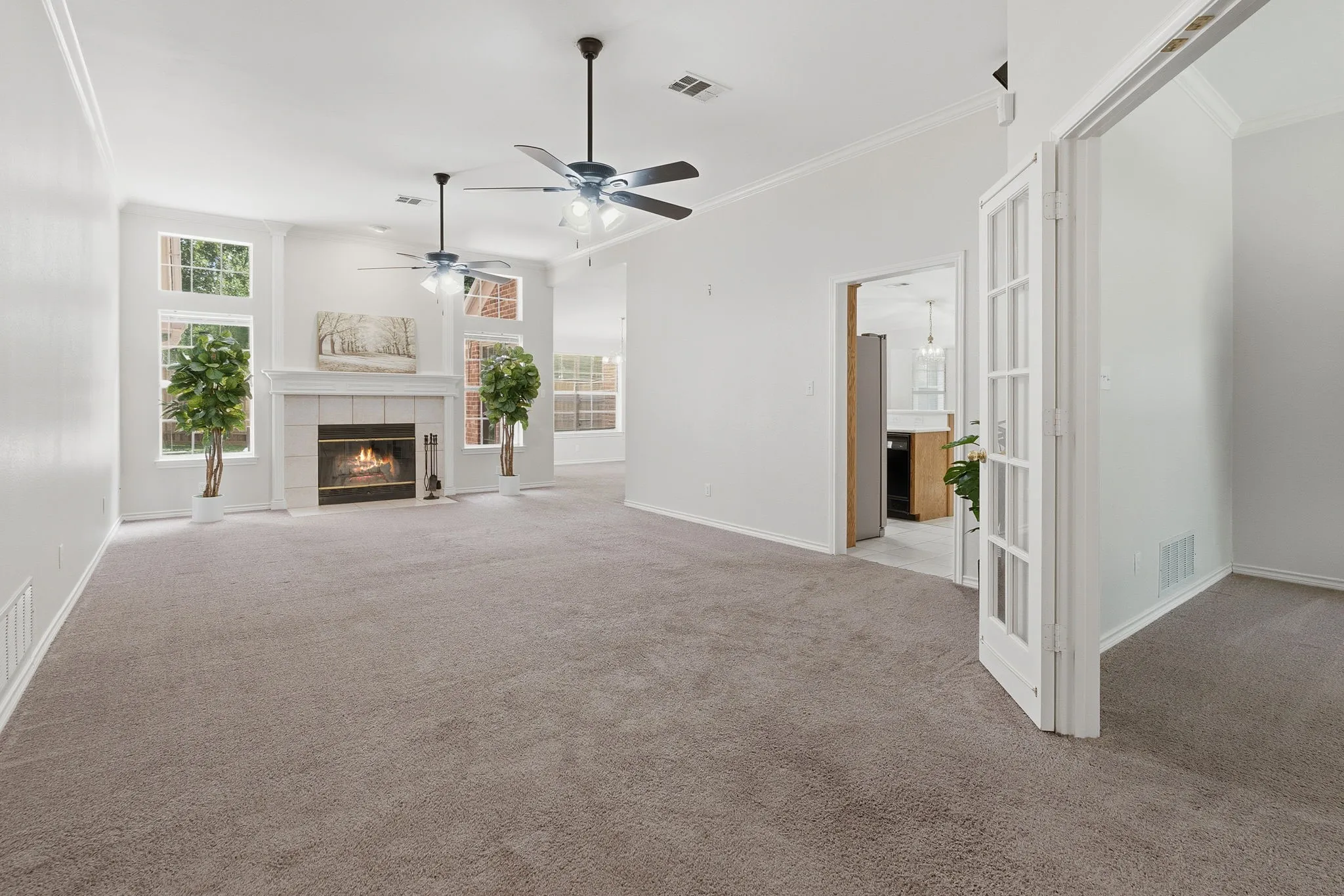 Spacious family room features a wood-burning fireplace with blower, generous windows, and two ceiling fans.