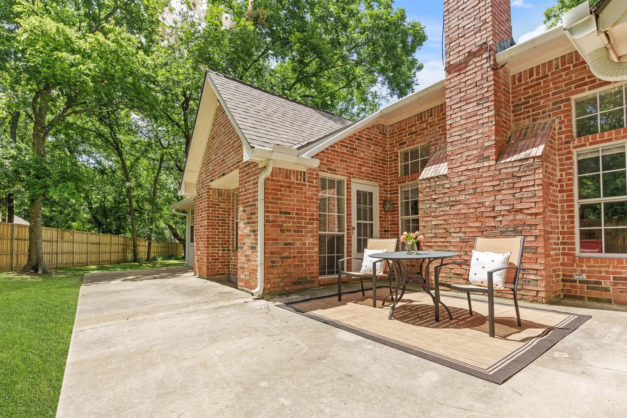 Extended back patio shaded by mature trees.