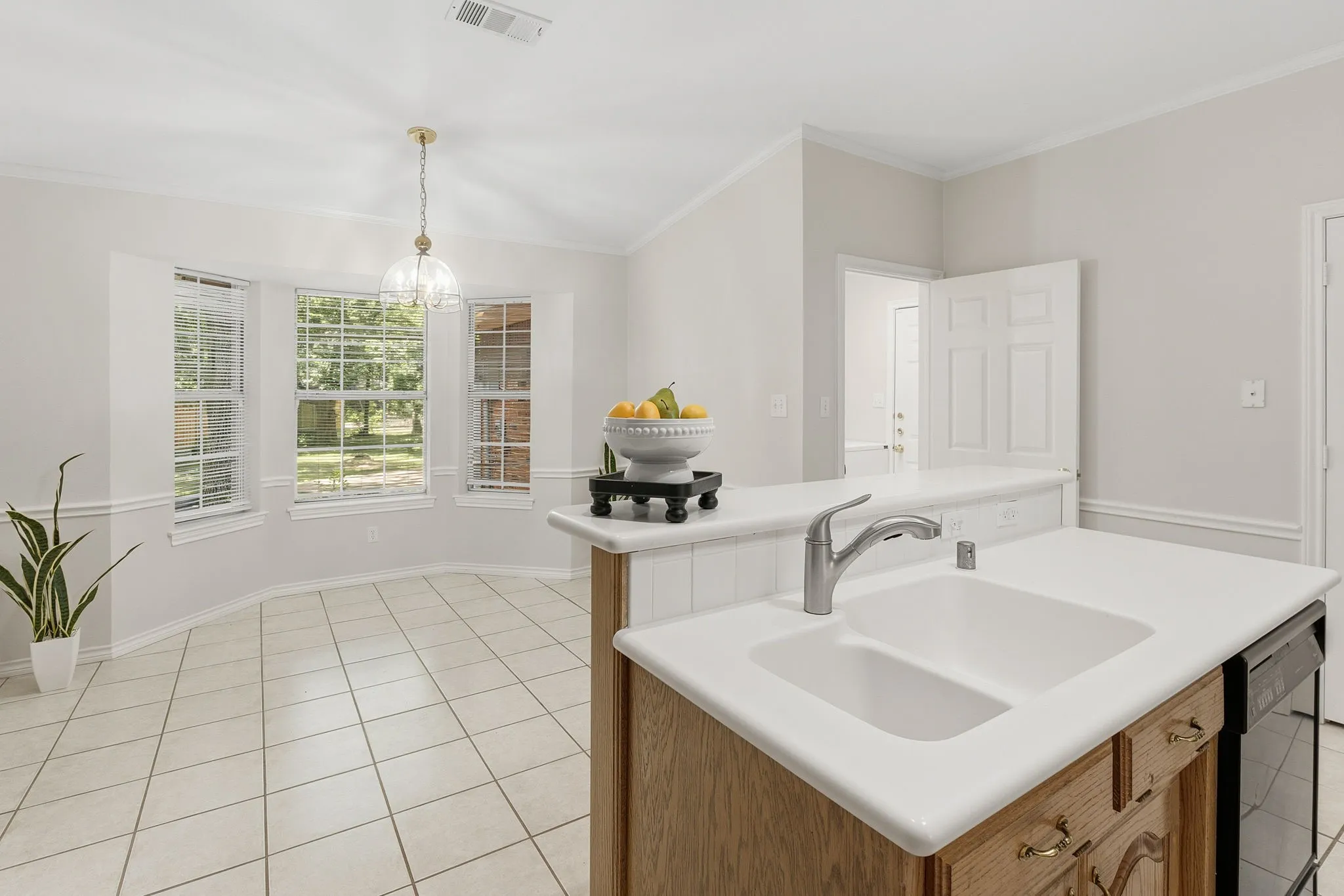 The kitchen offers custom wood cabinetry, electric appliances, double ovens, a serving bar, great cabinet space, two pantries, and a sunny breakfast area with a bay window