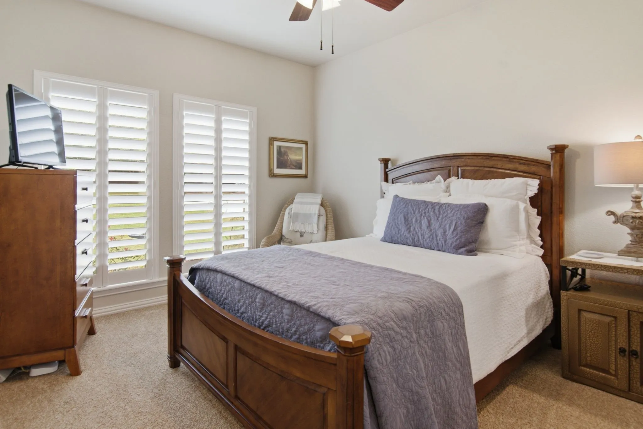 One of two nice size secondary bedrooms with plantation shutters and ceiling fan.