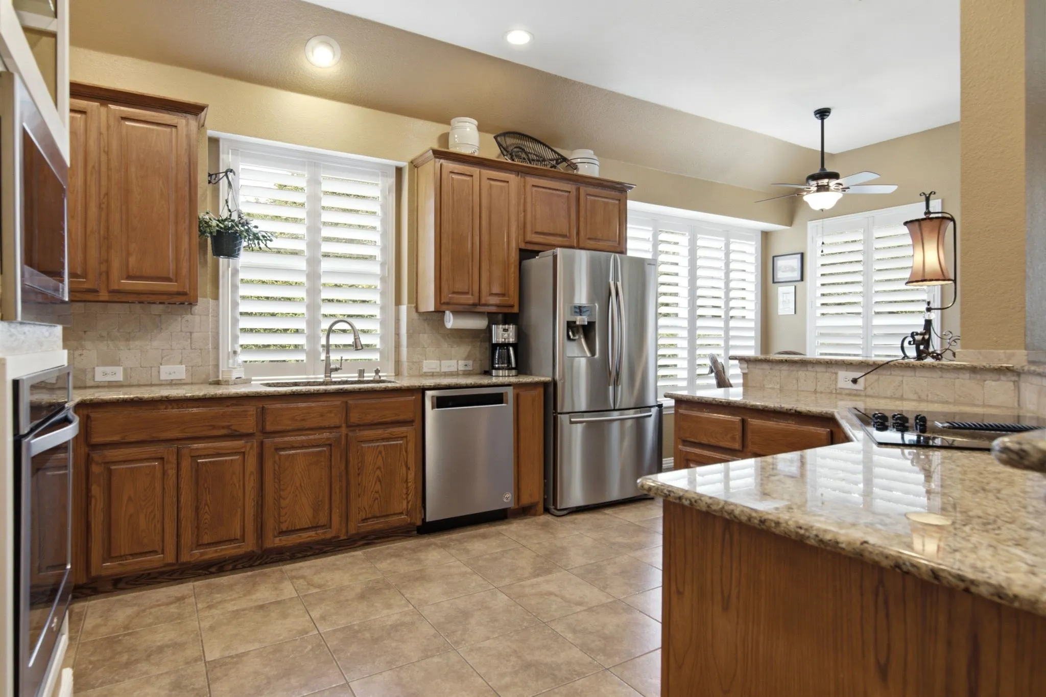 The eat-in kitchen features granite countertops, tumbled marble backsplash and plenty of counter space.