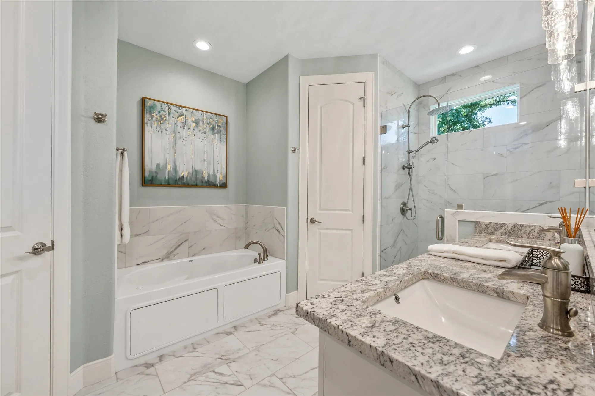 No expense spared in this beautiful up-to-date primary bathroom with his and hers closets.
