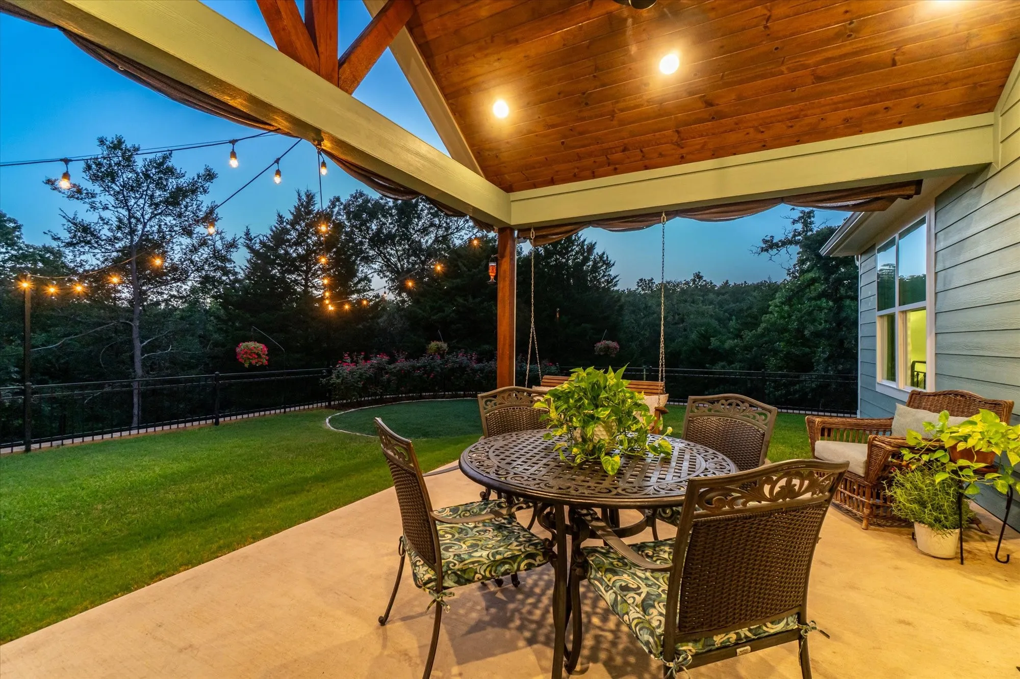 Atmosphere with the cafe lights at dusk.  Pitch ceiling lined with pine wood just one more upscale custom feature of this home.