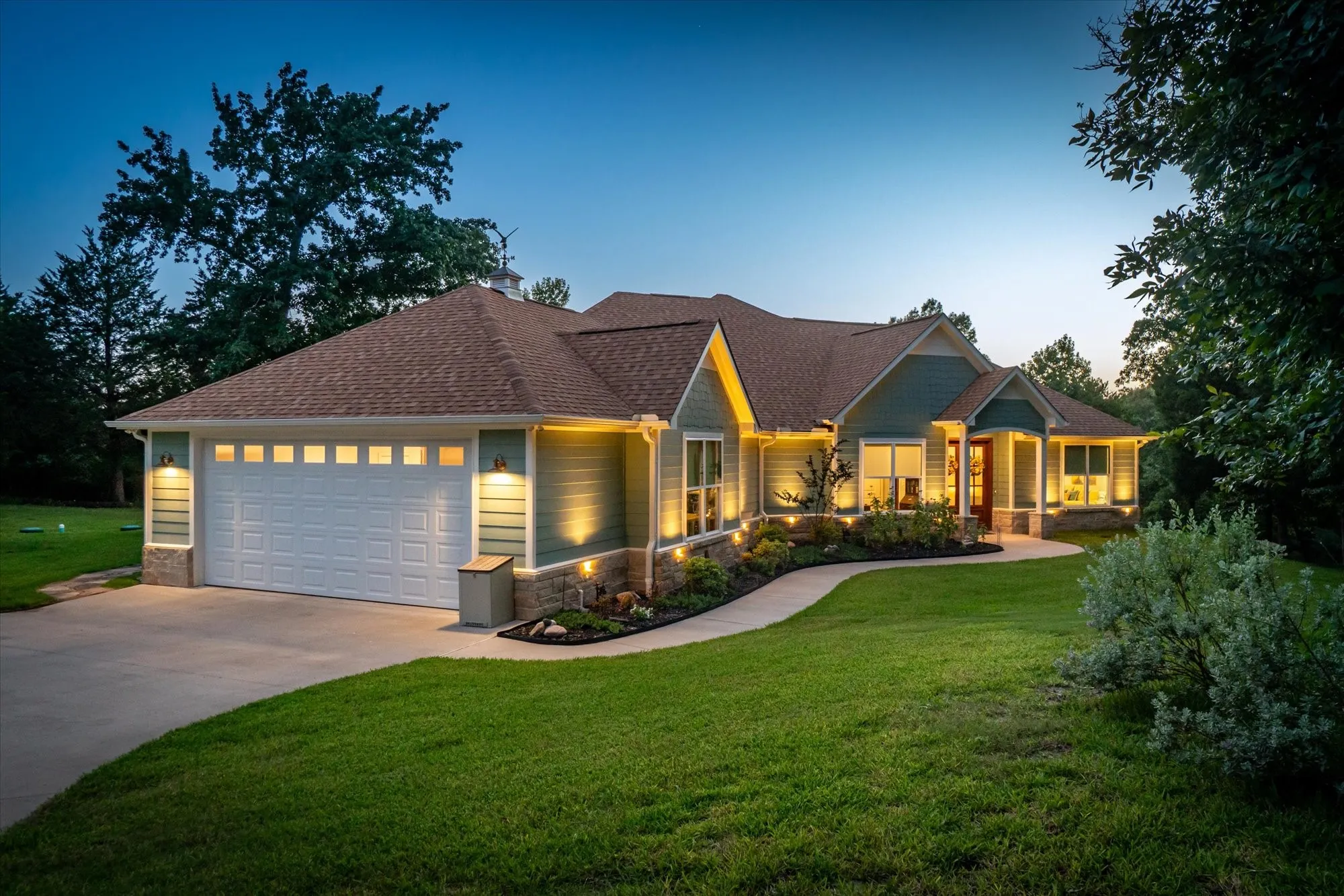 Beautiful landscaping line this gorgeous home.  View of 3 car tandum garage.  What you can't see is the golf car garage door around the corner.
