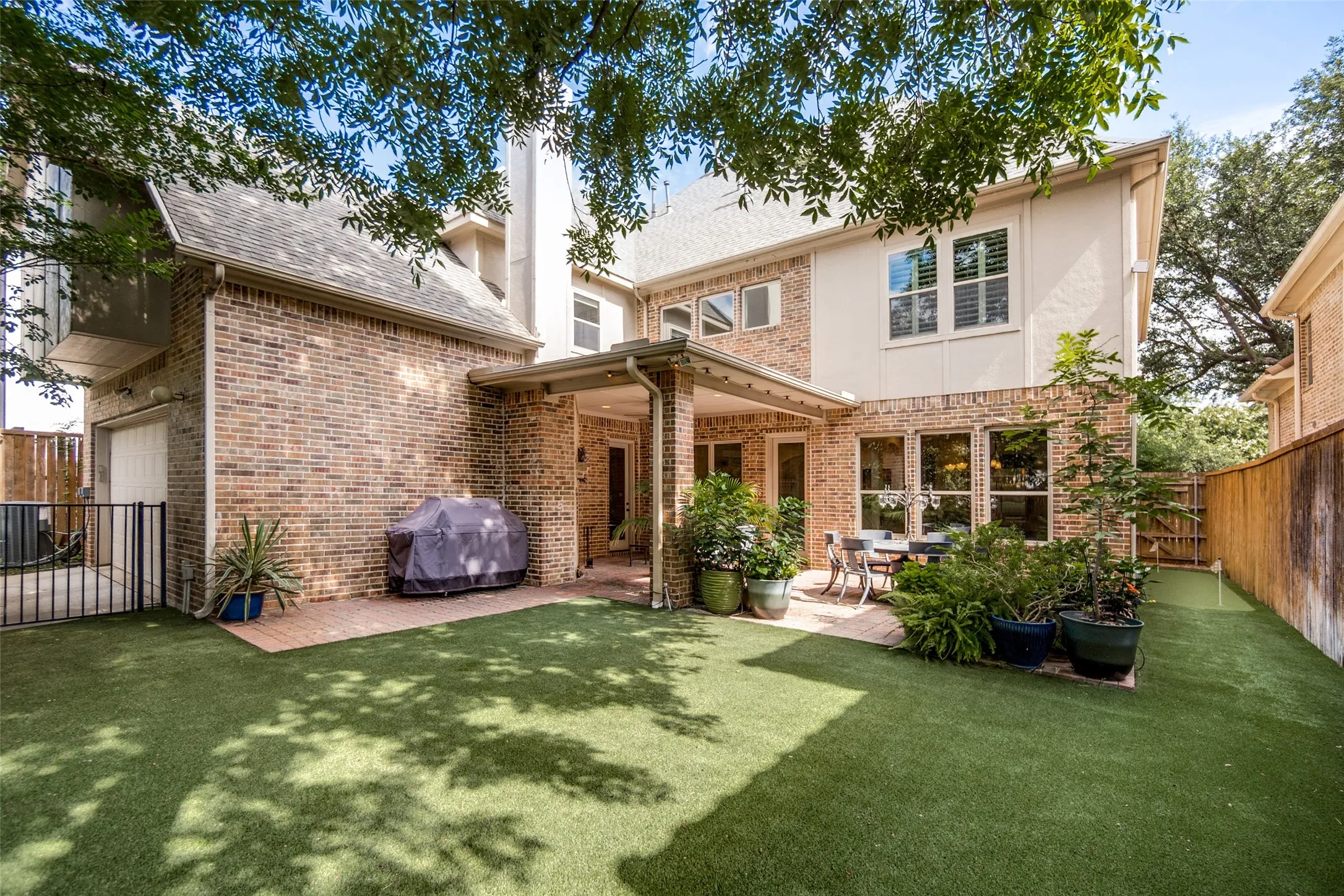 Rear exterior featuring a brick facade with stucco accents and multiple windows