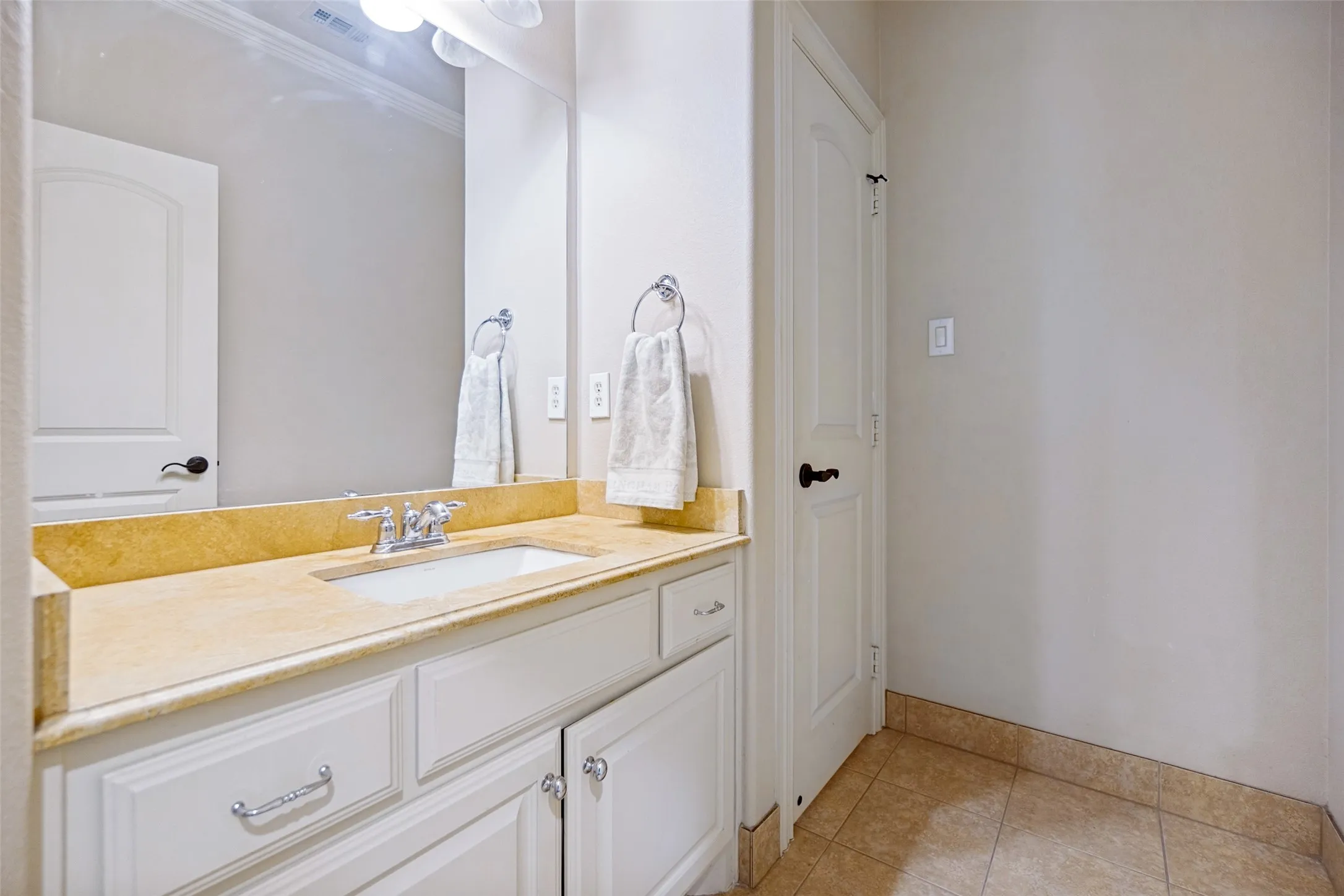 Vanity with integrated sink, stone countertop, and chrome faucet