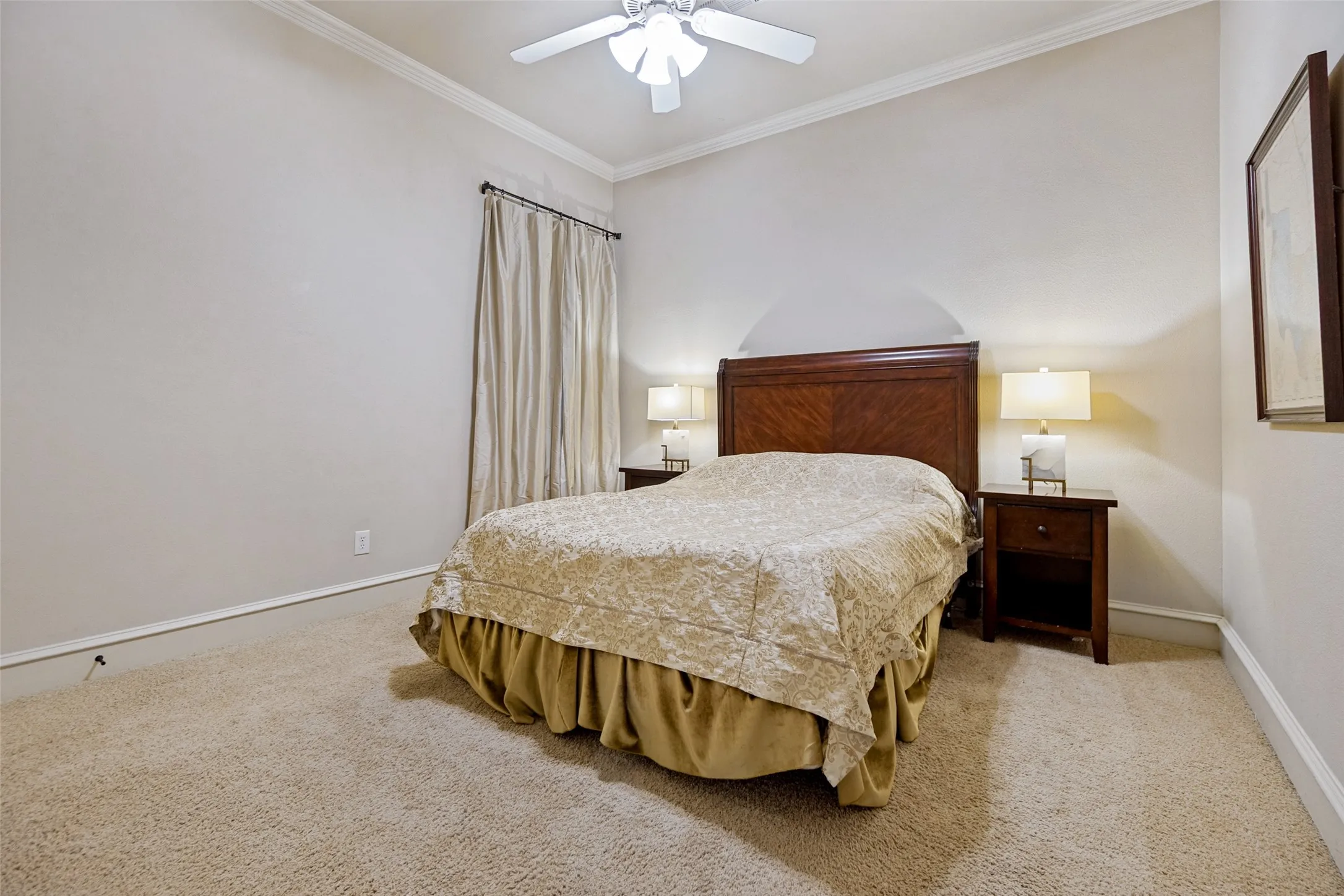 Downstairs bedroom featuring neutral carpeting and walls, crown molding, and a vaulted ceiling.