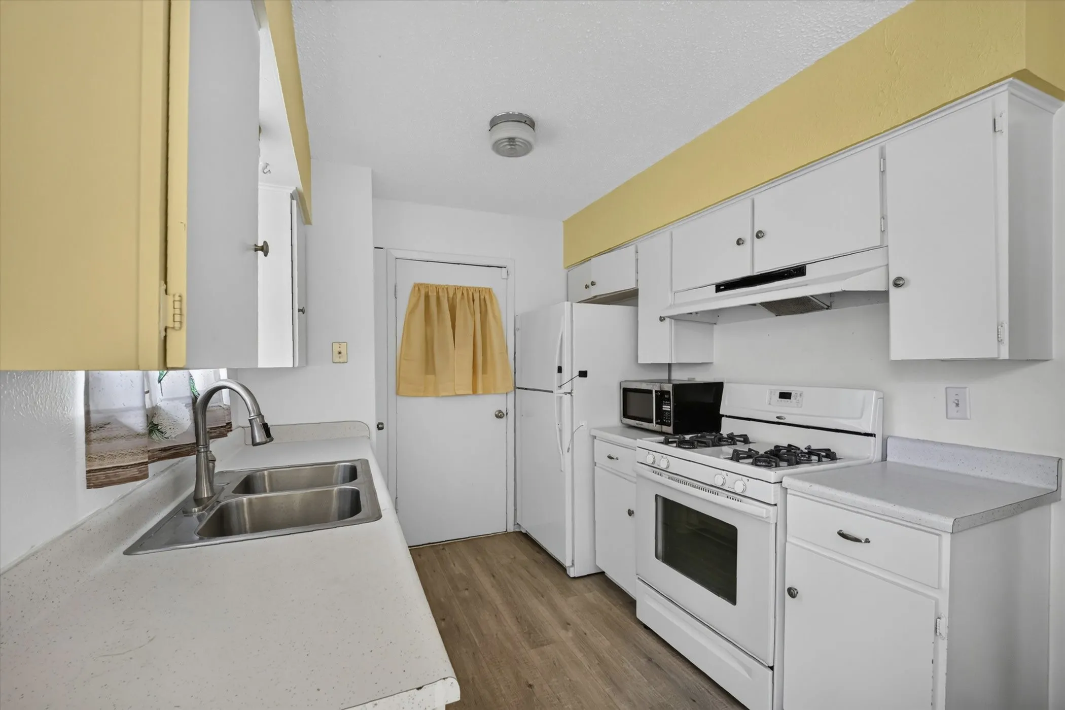 Kitchen featuring white cabinetry and light-toned countertops
