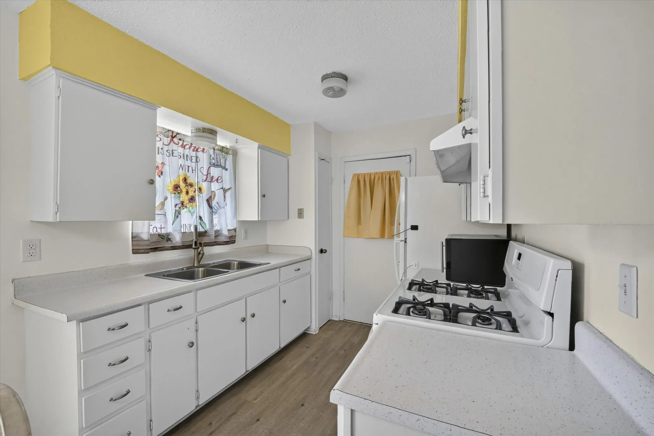Kitchen featuring white cabinetry and light-toned countertops