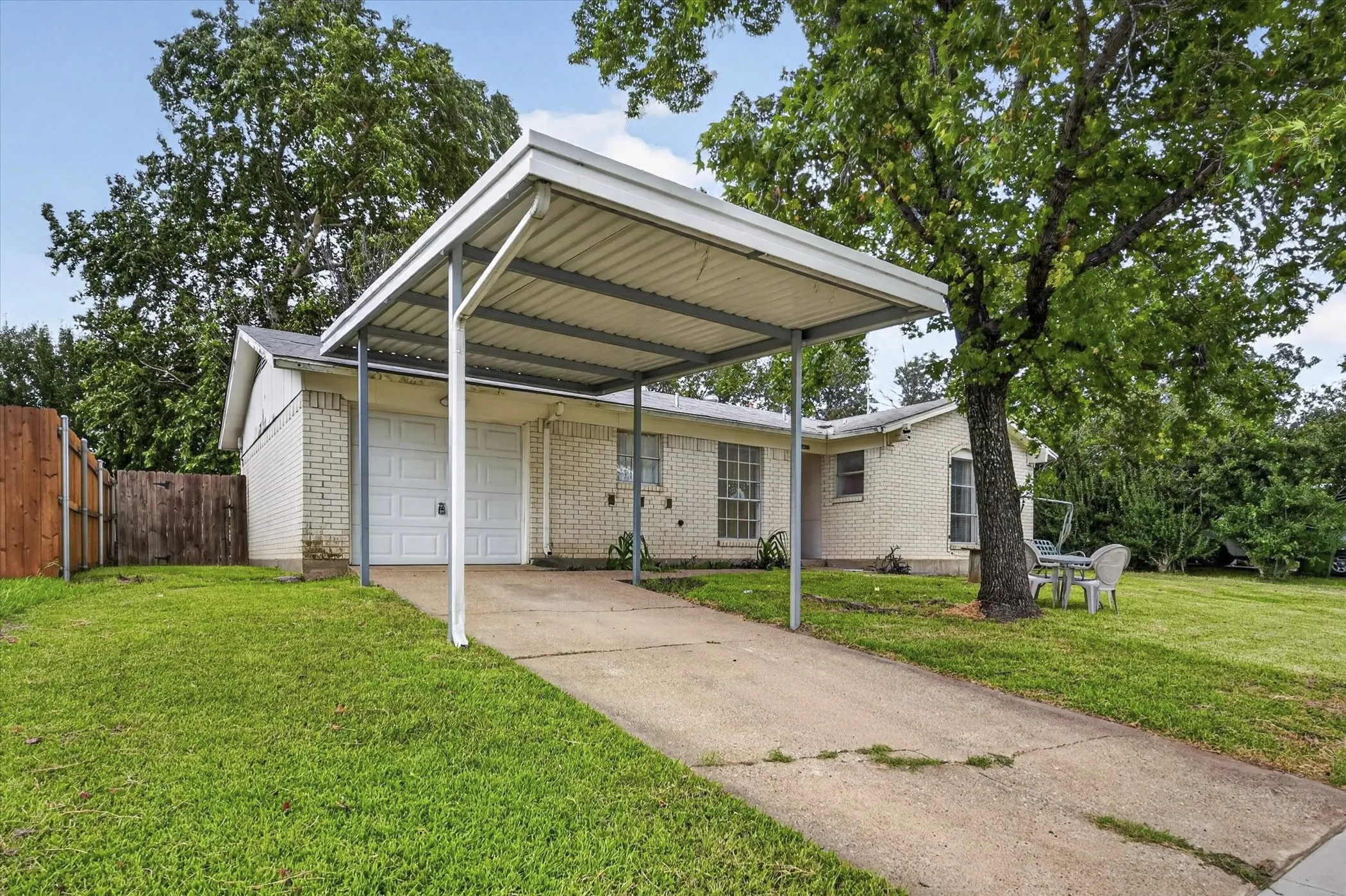 Brick exterior home featuring a two-car carport
