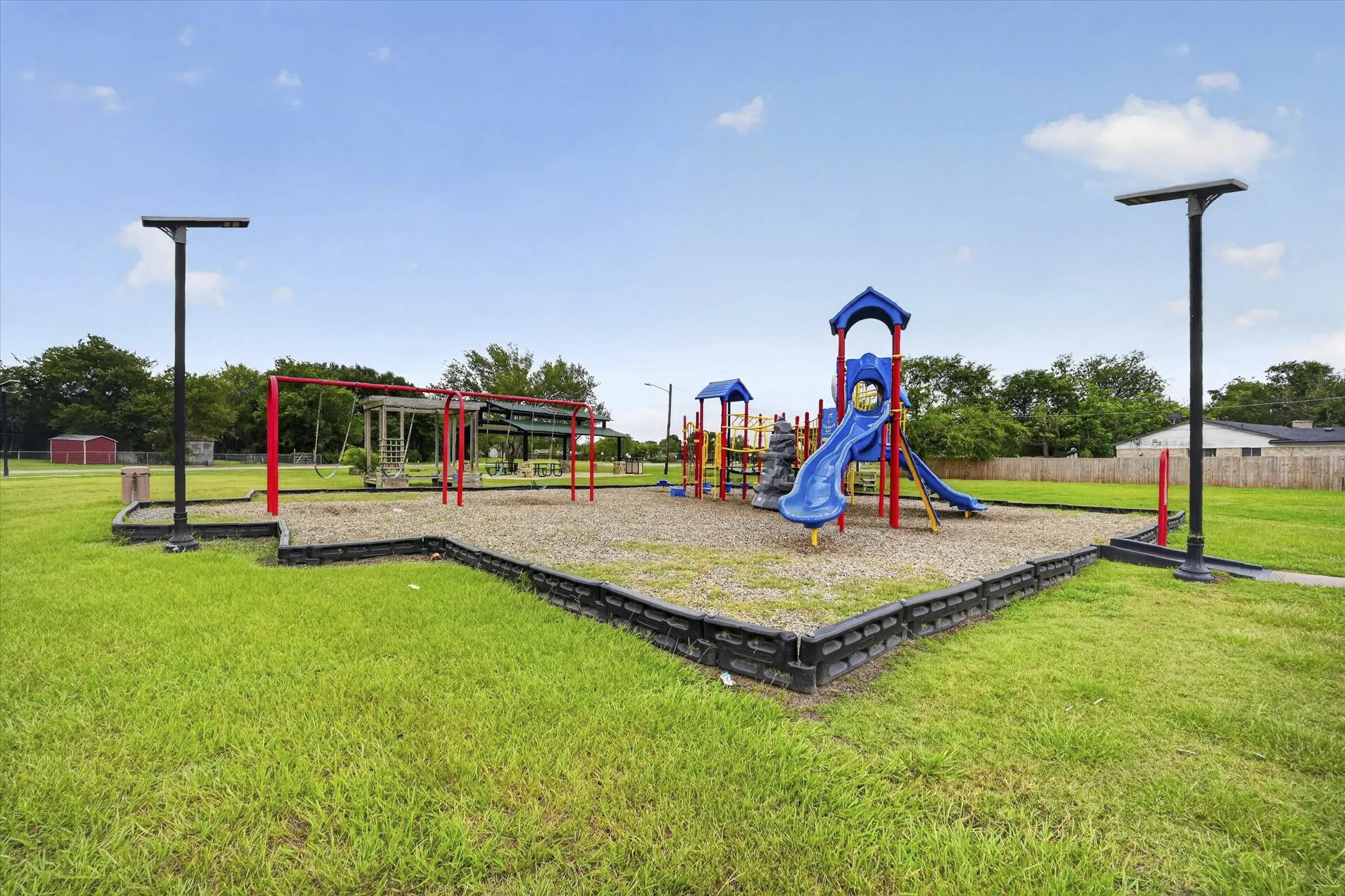 Recreational playground area featuring multiple play structures, swings, and slides