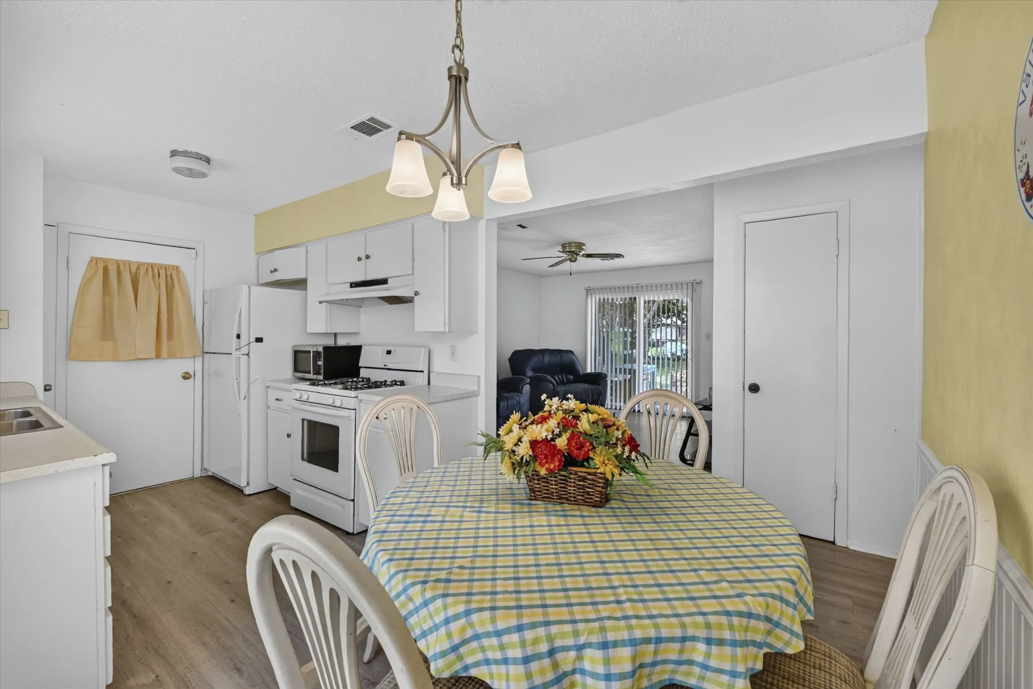 Dining area with chandelier lighting and wood-finish flooring