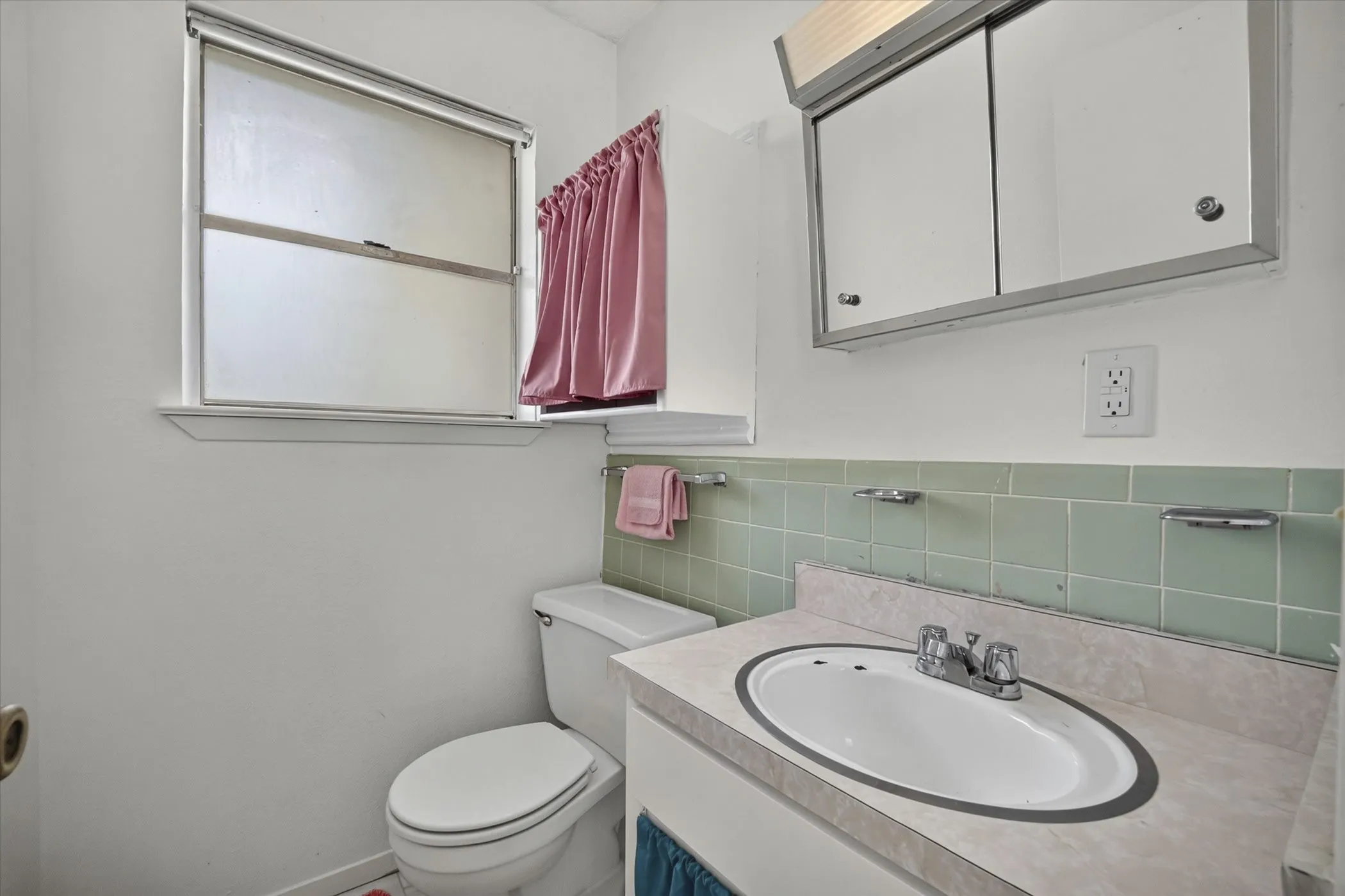 Bathroom featuring a built-in vanity with an oval sink, chrome faucet, and integrated countertop