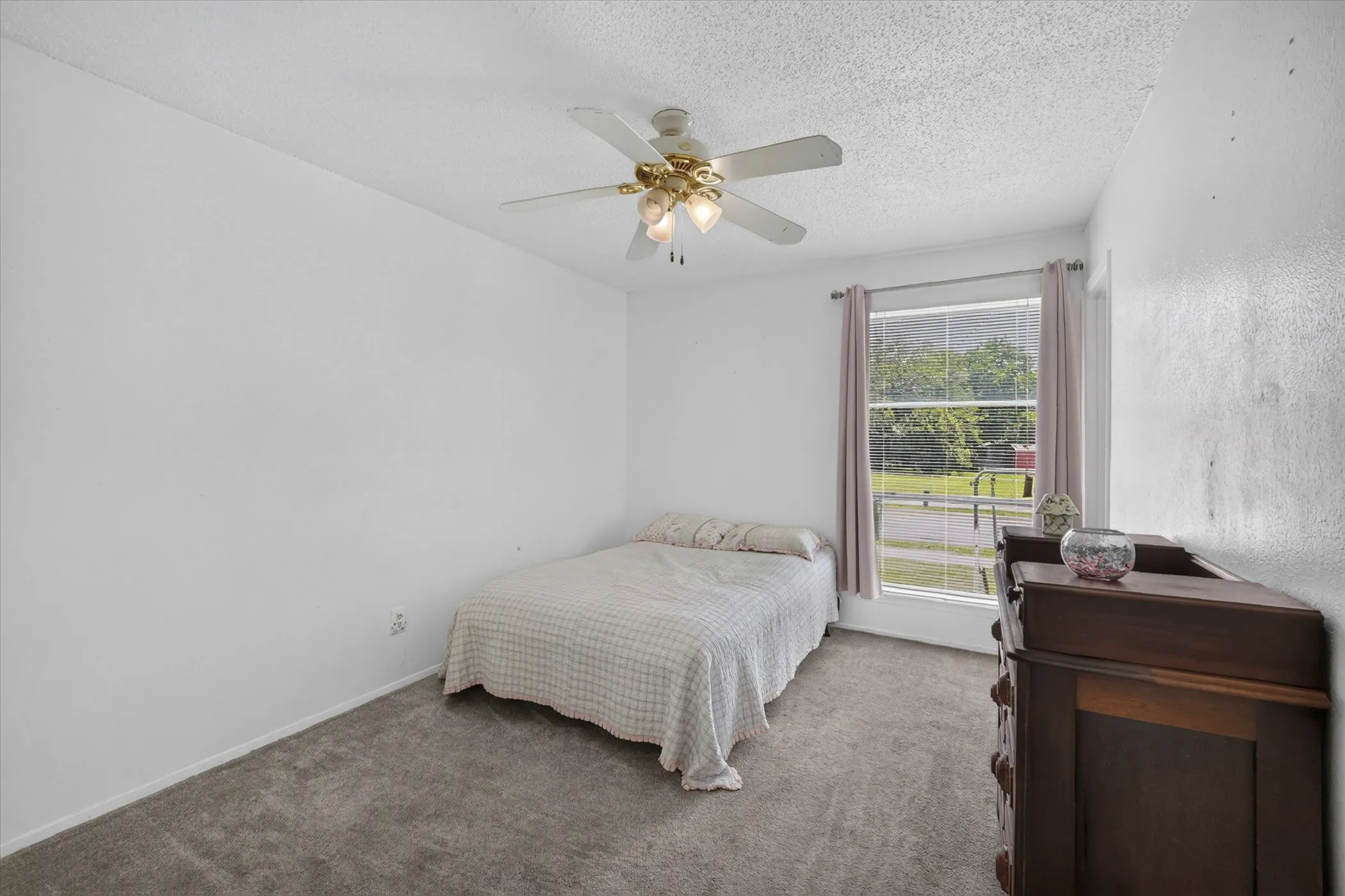 Carpeted room featuring a ceiling fan with integrated lighting, a double-hung window, and white painted walls