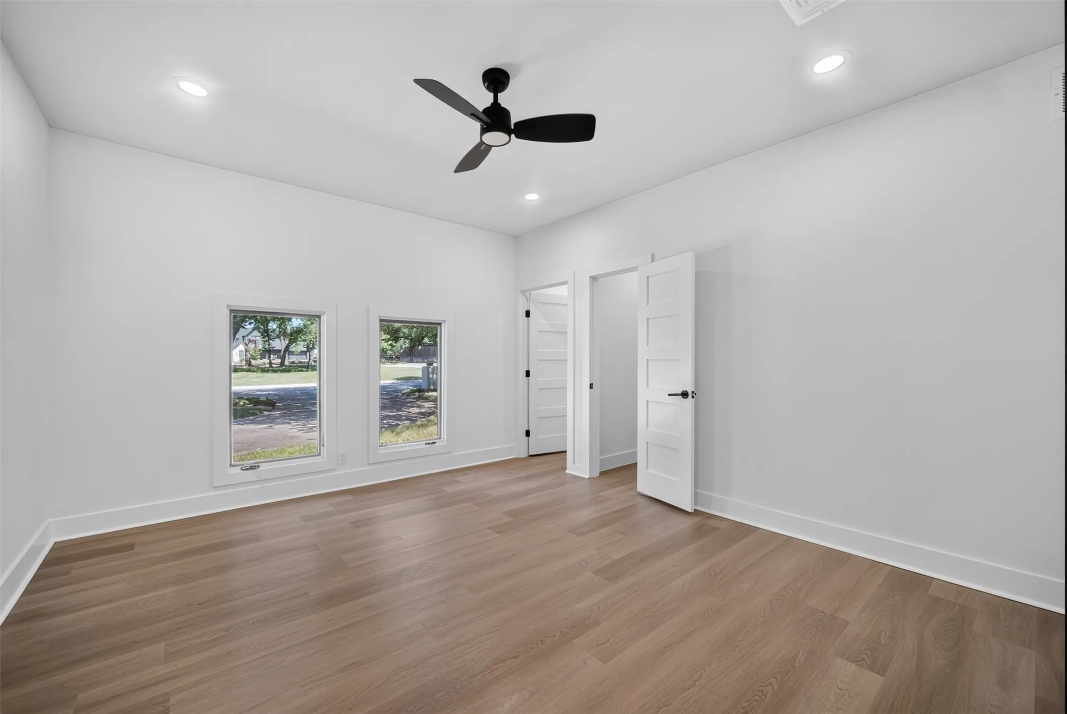 Room featuring wood-finish flooring, recessed lighting, and a ceiling fan