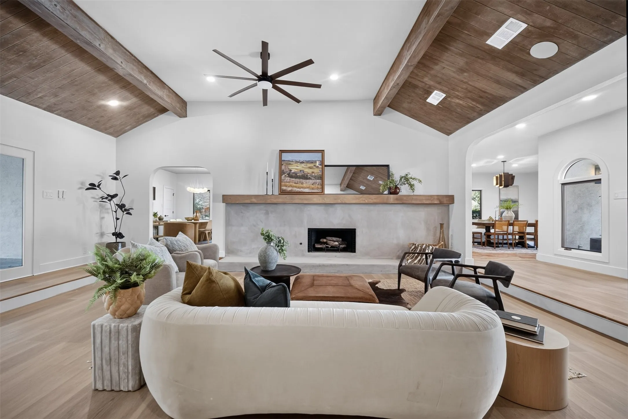 Vaulted wood-paneled ceiling with exposed beams and a modern ceiling fan
