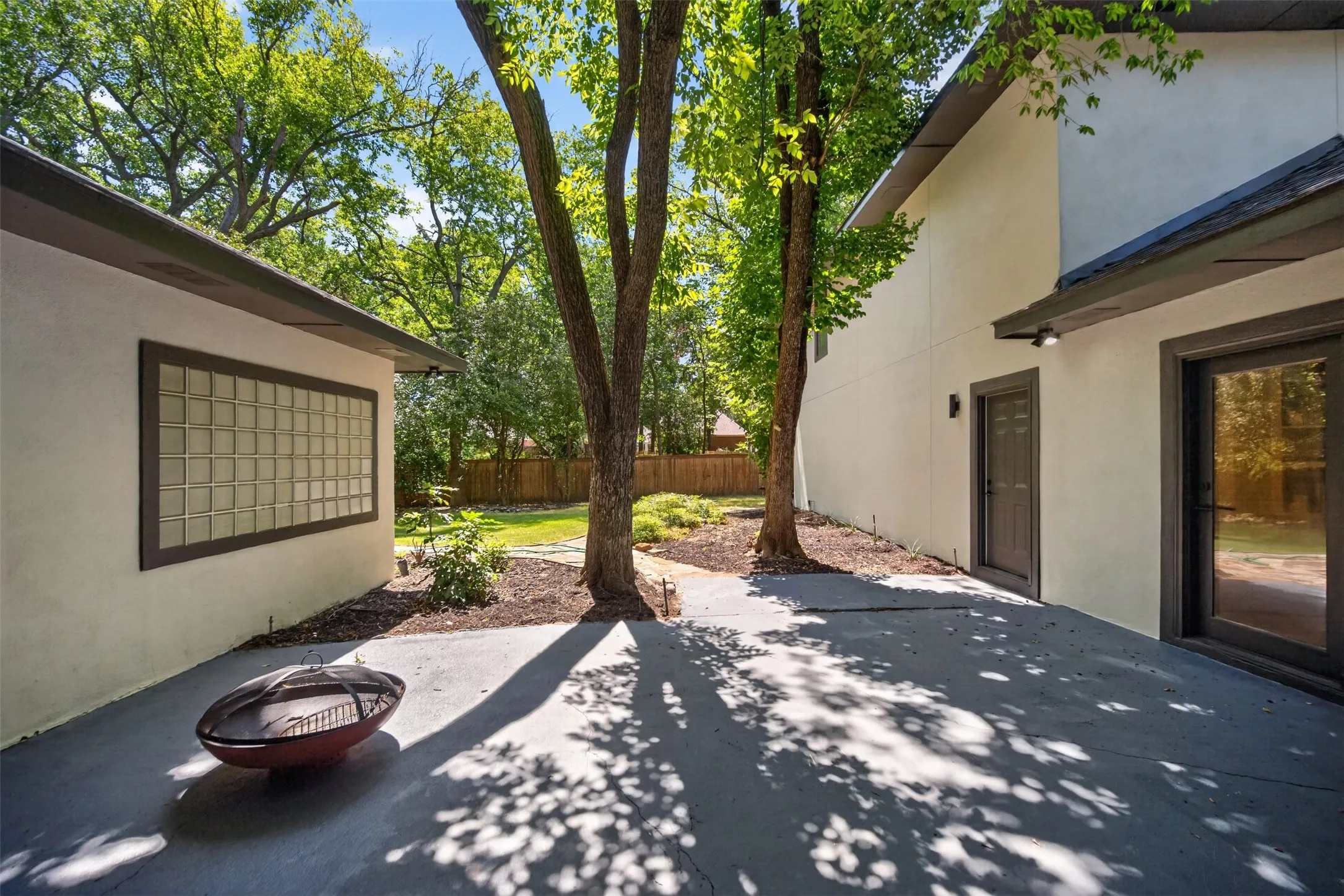 Concrete patio with mature trees providing natural canopy