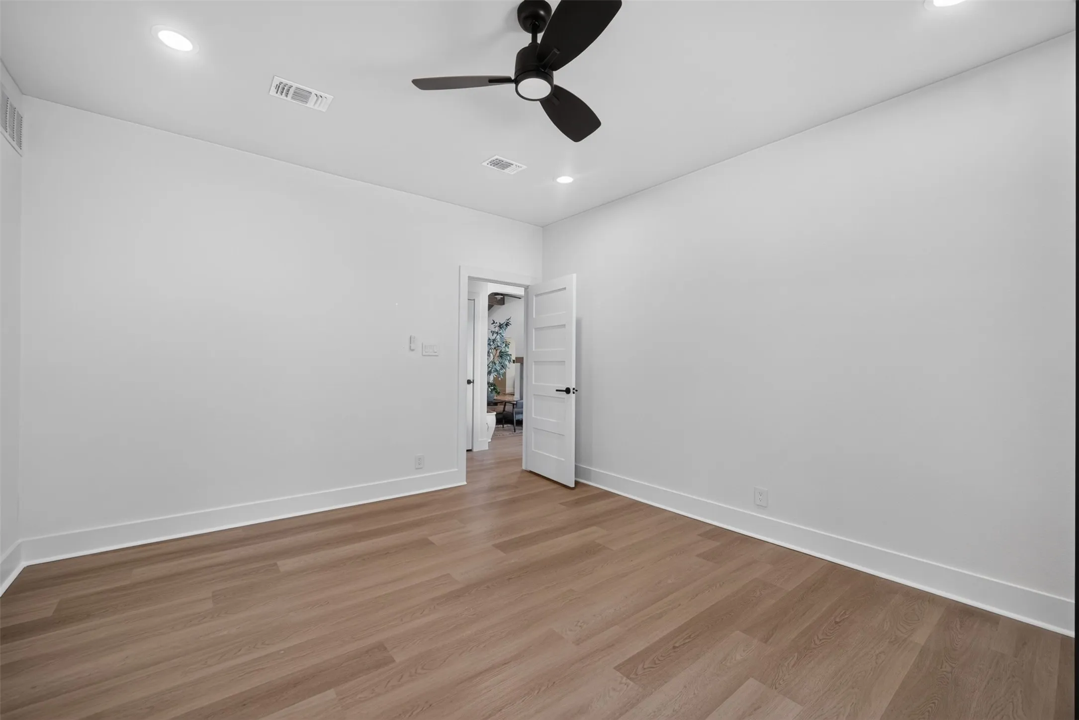 Interior room featuring wood-finish flooring and white baseboards