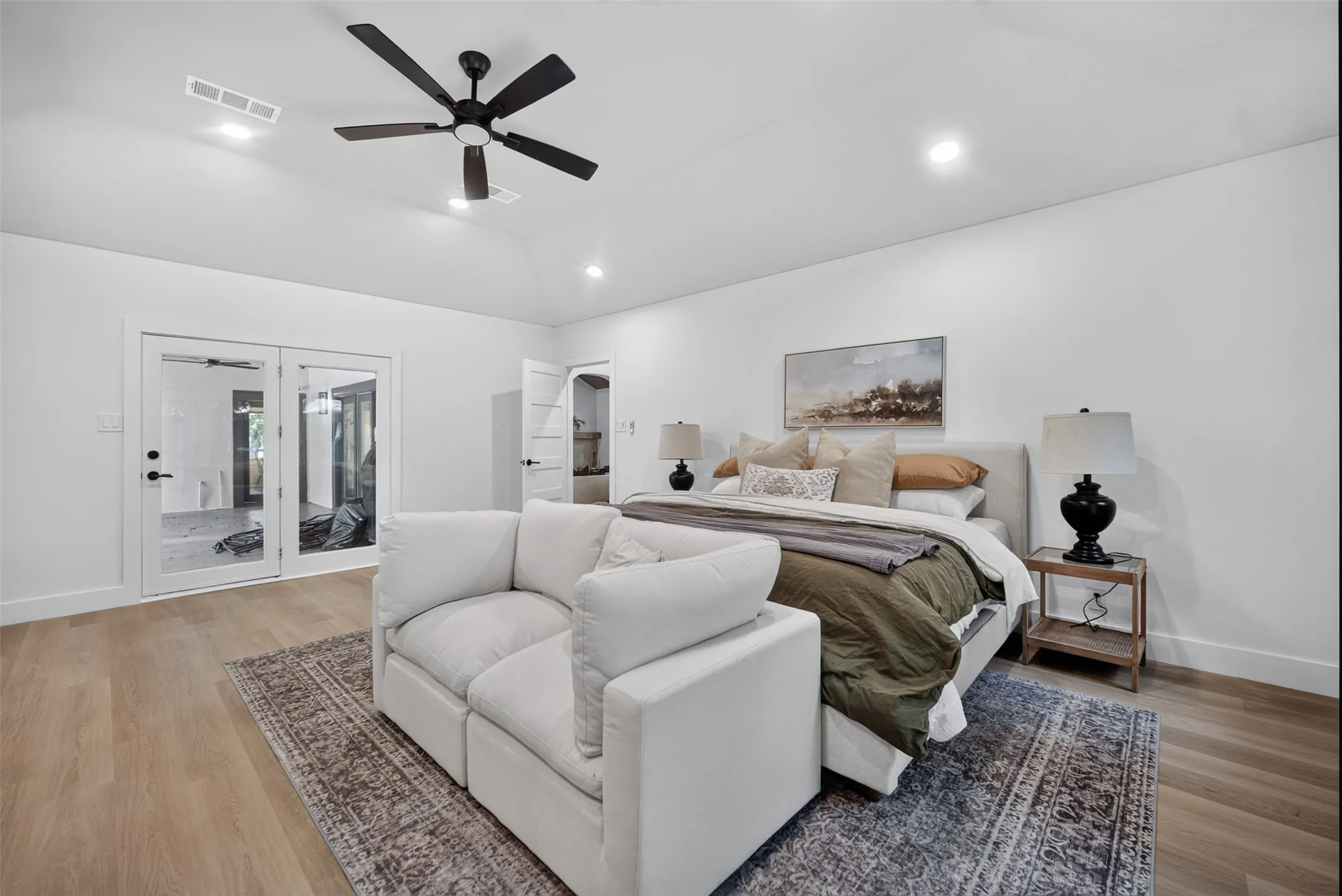 Spacious room featuring light wood-finish flooring, recessed lighting, and a modern ceiling fan
