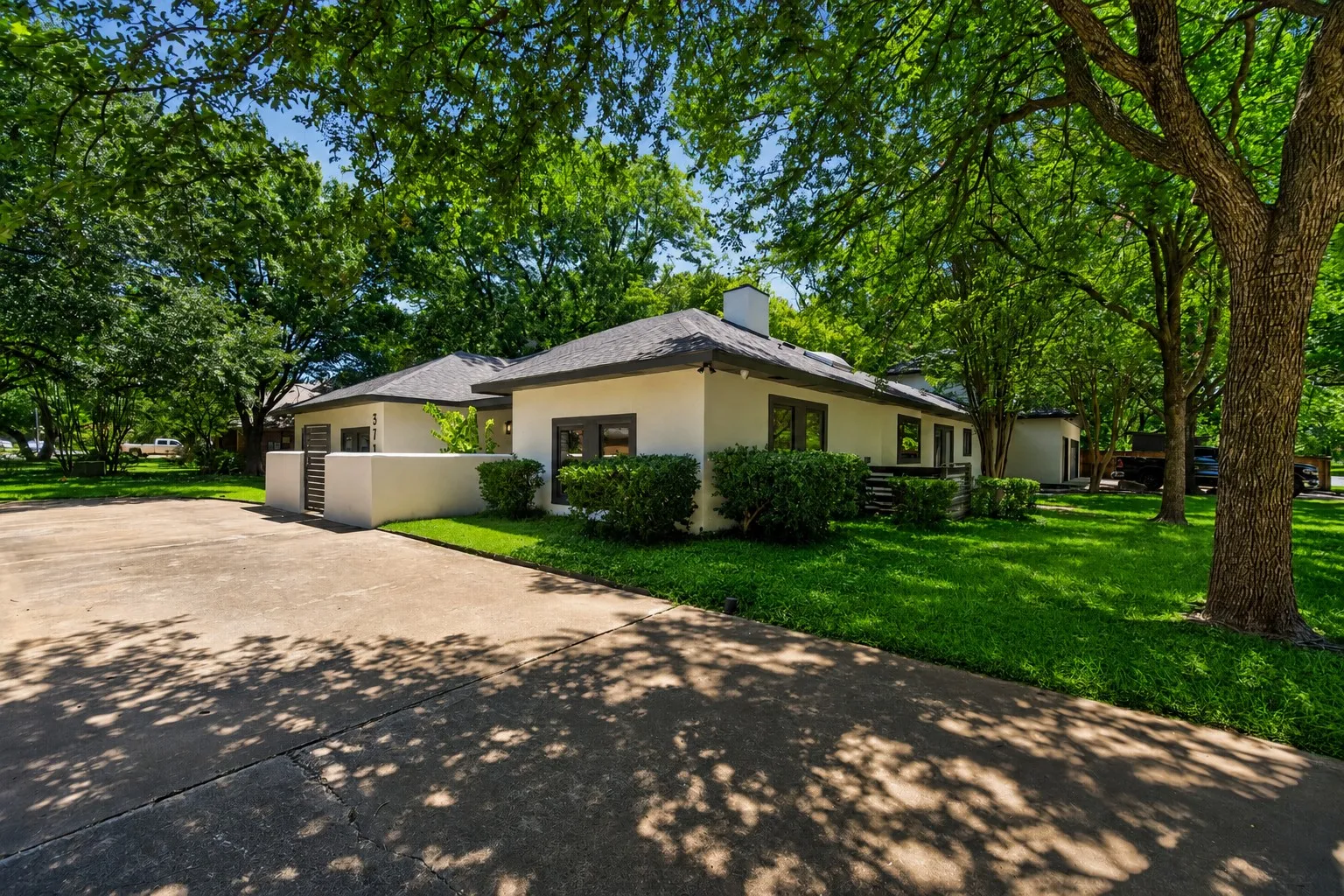 Single-story exterior with stucco finish and dark trim windows