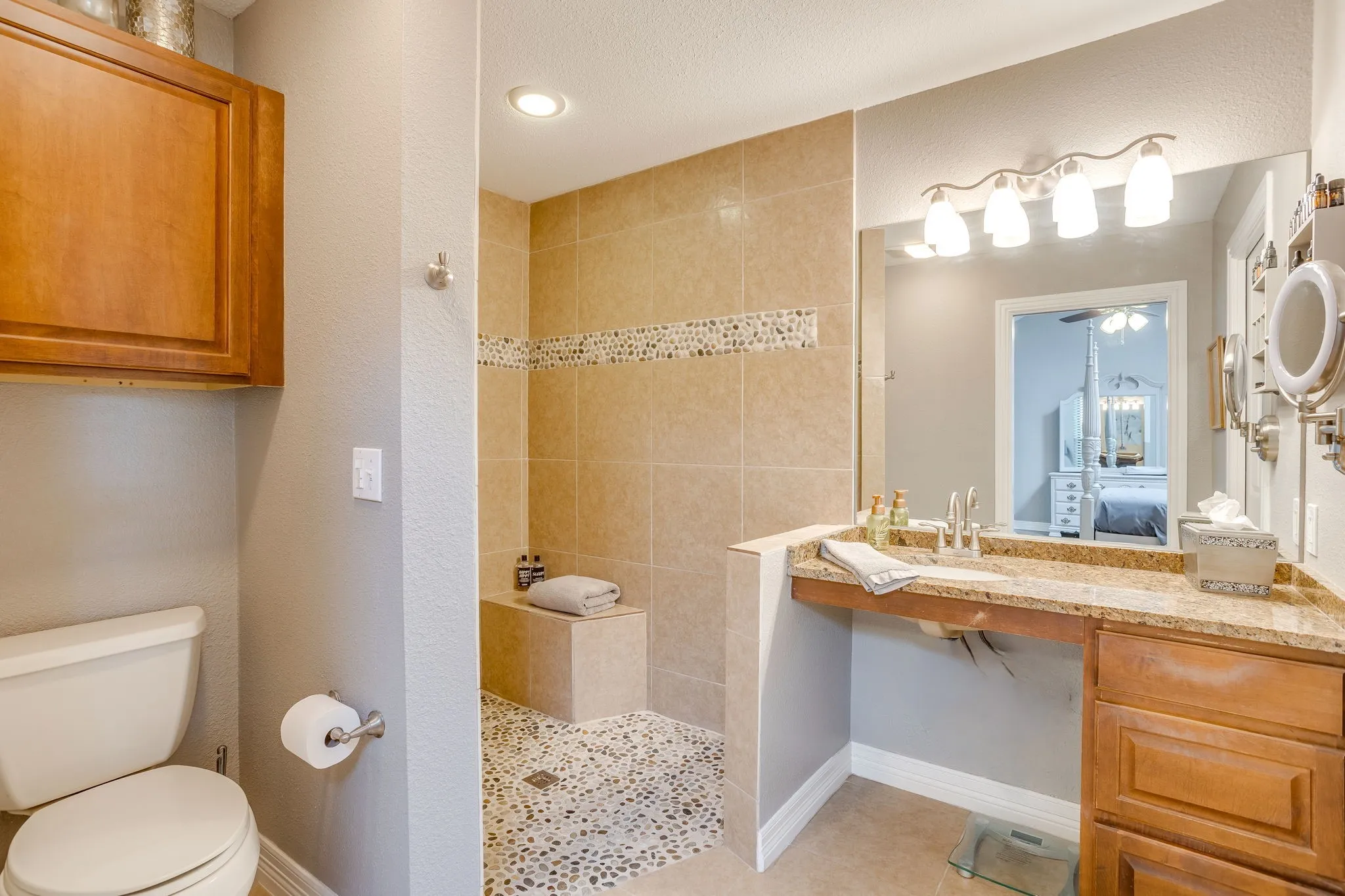 Remodeled primary bathroom with wheelchair accessible shower and vanity.