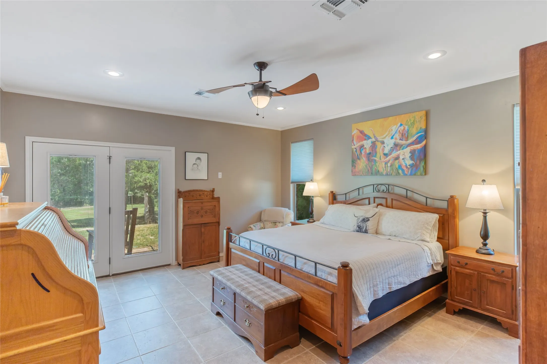Primary bedroom suite with a ceiling fan, large windows, and a private exit door to the outdoors.