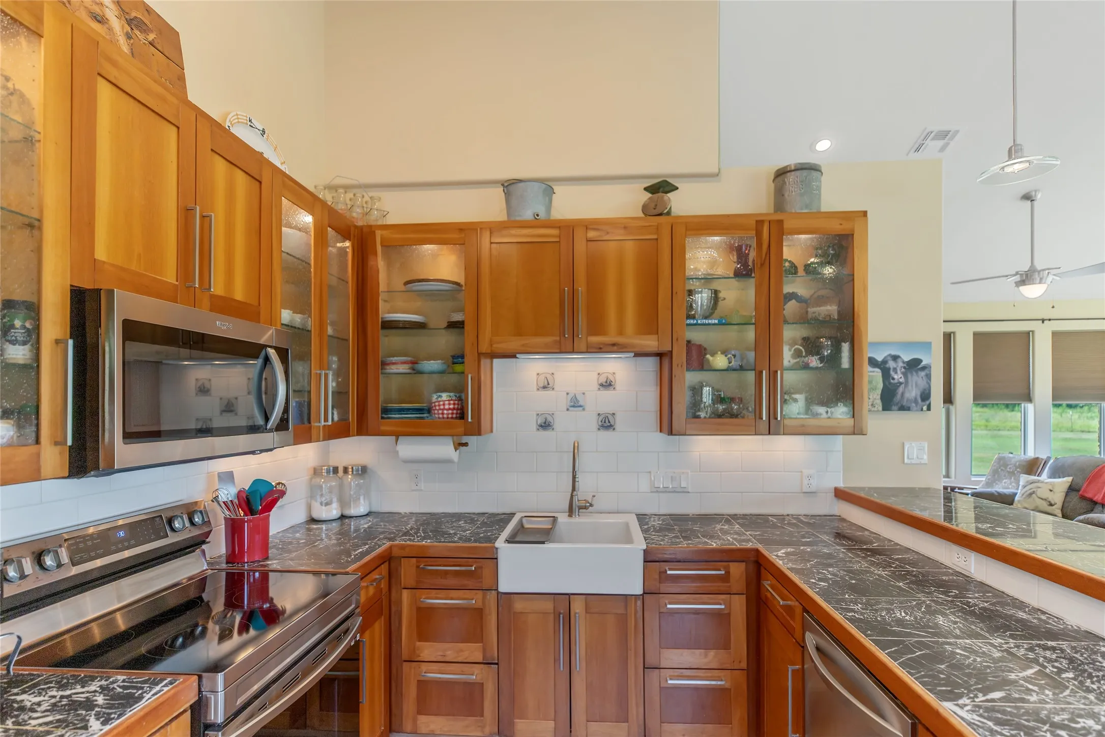 Close up of kitchen highlighting a classic farm sink, premium appliances, and custom wood finished ceiling.